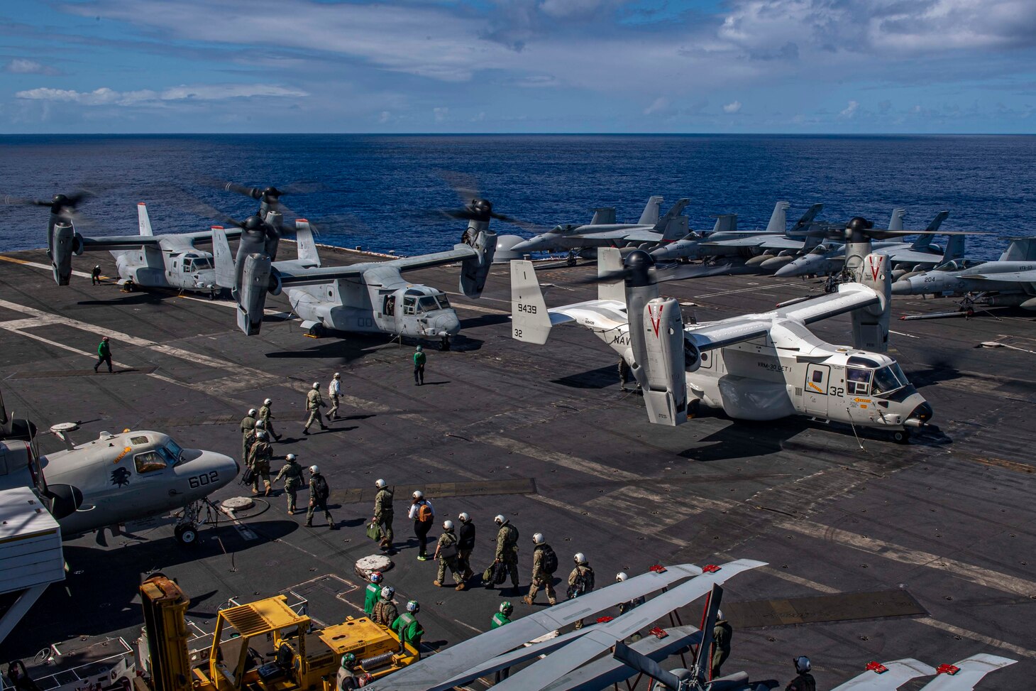 Senior military leadership cross the flight deck to depart Nimitz-class aircraft carrier USS Carl Vinson (CVN 70), Feb. 9, 2022.