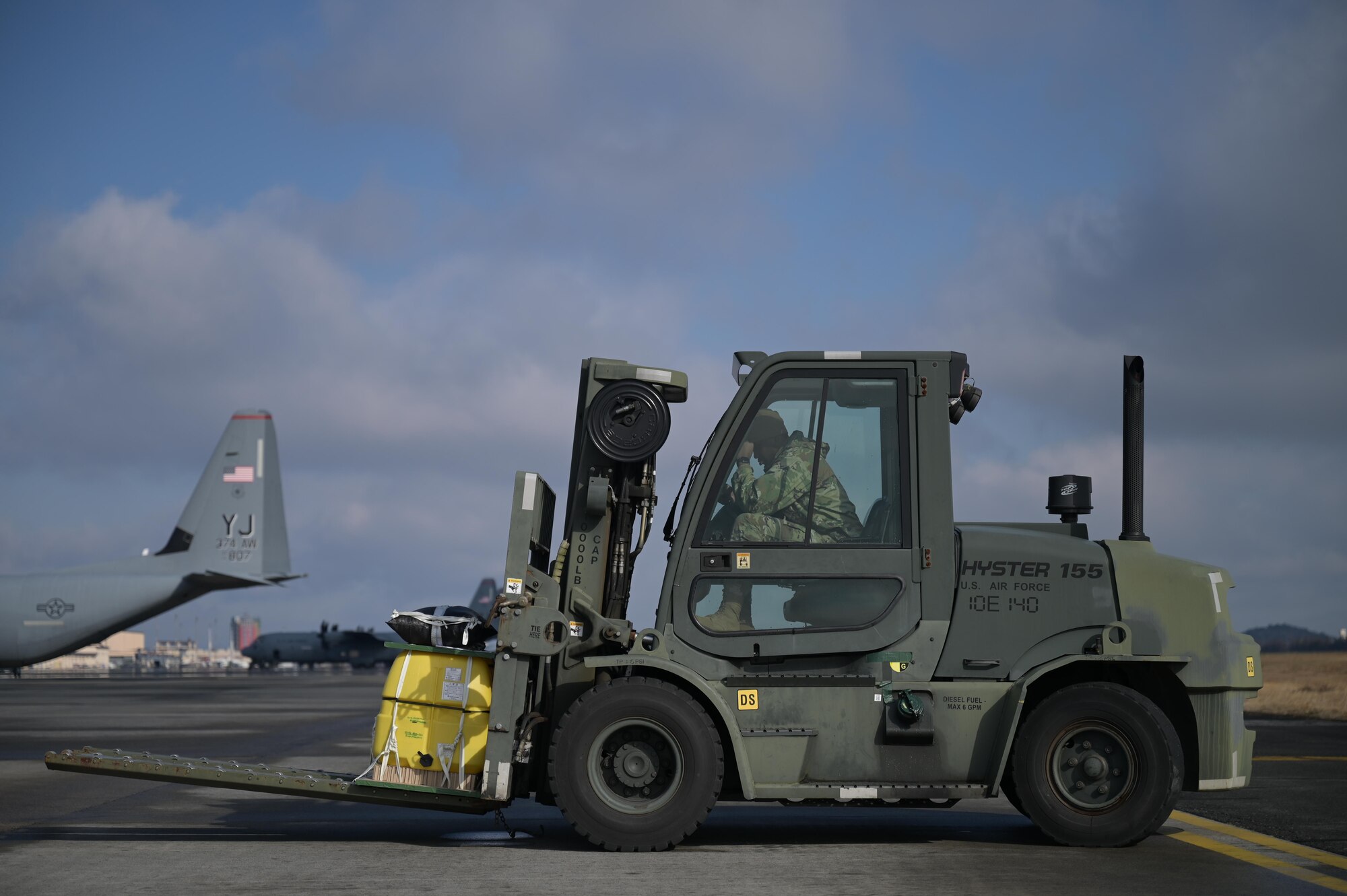 An Airman from the 374th Logistics Readiness Squadron waits to load cargo on a C-130J Super Hercules on the flightline at Yokota Air Base, Japan, during exercise Tomodachi Rescue 22 Feb. 11, 2022.