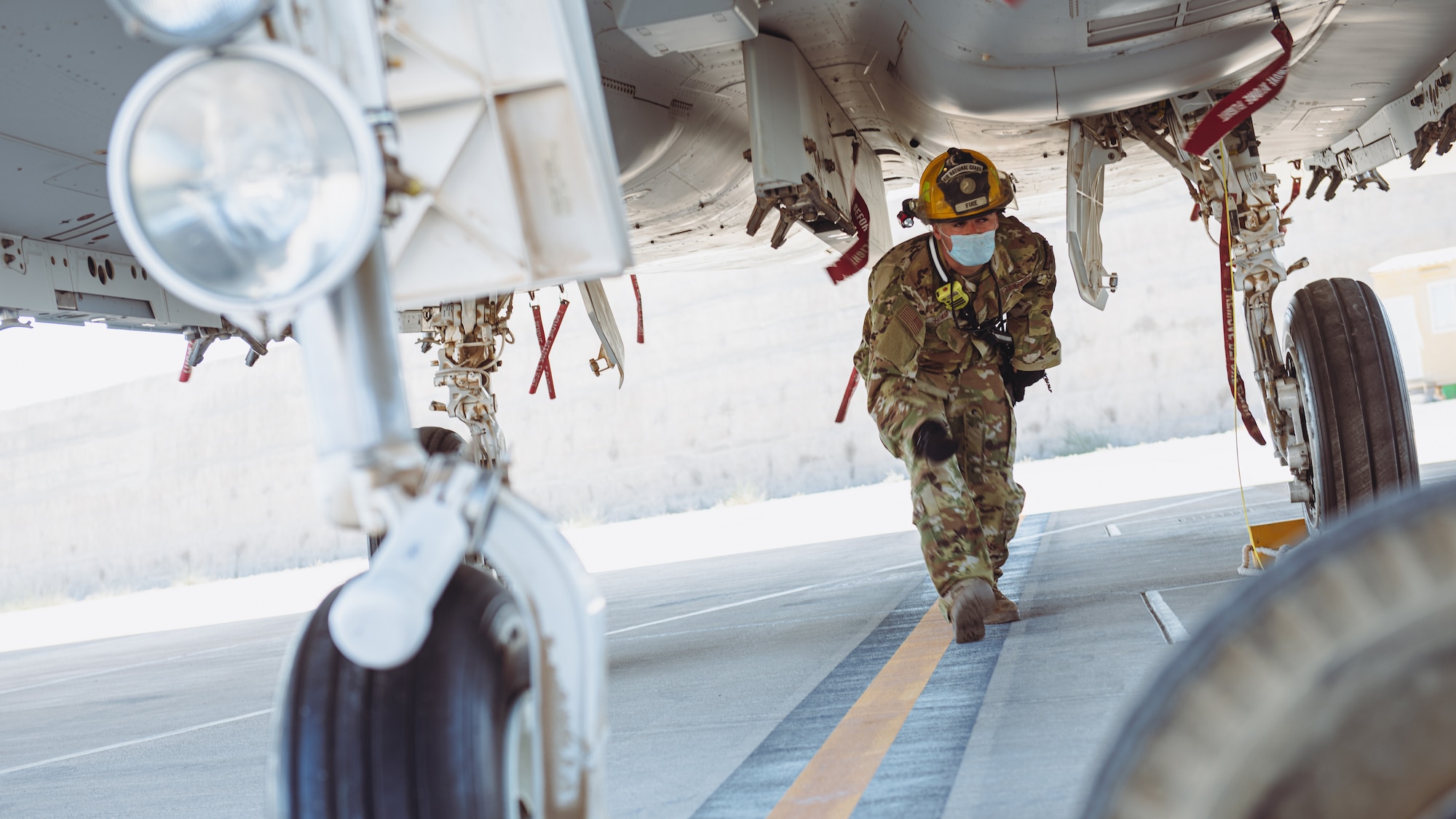 Airman walks underneath plane.