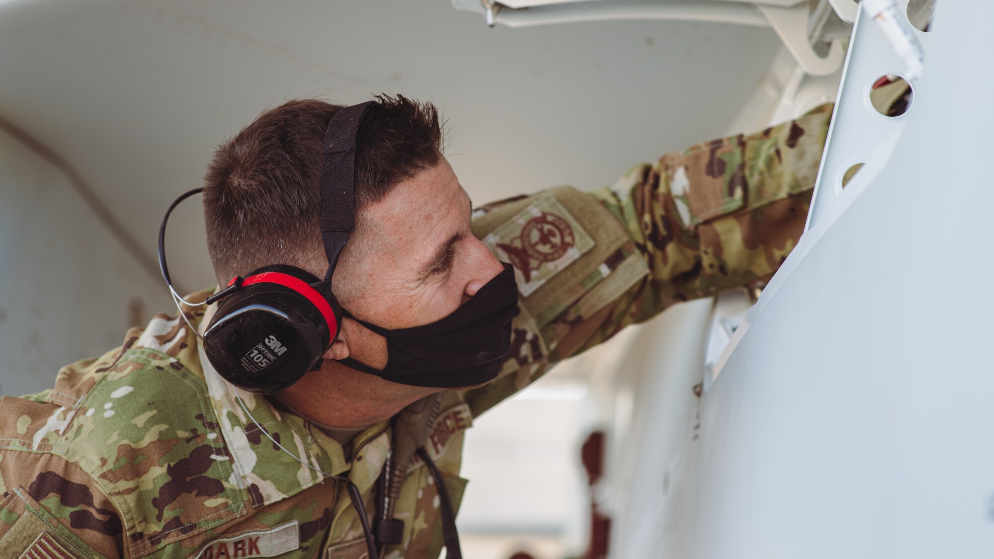 Airman inspects plane compartment.