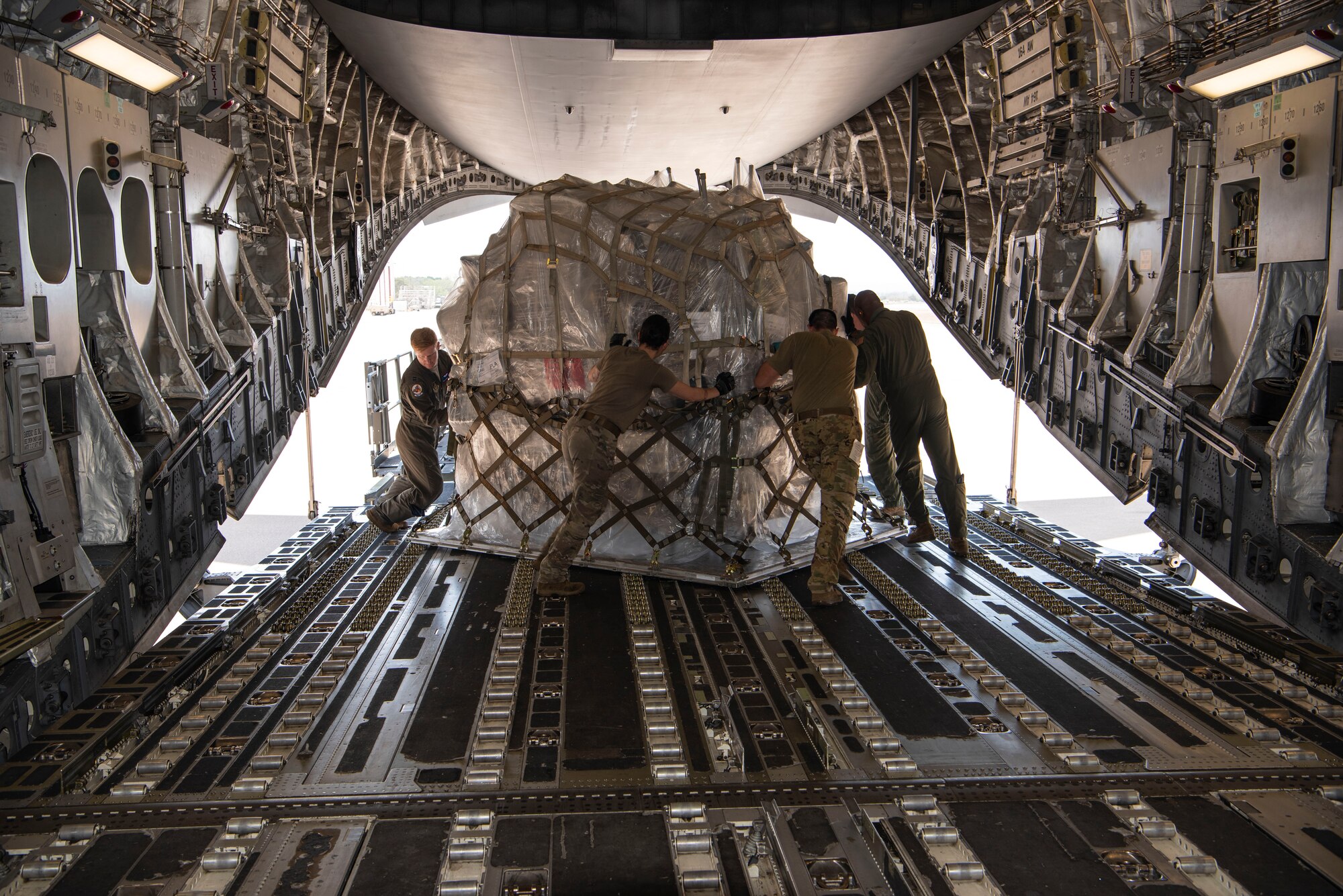 Air Force Reserve aircrew members offload food and medical supplies from the rear of a C-17 Globemaster III aircraft at Soto Cano Air Base, Honduras, as part of a weekend combined aircrew training and humanitarian delivery mission in Central America, Feb. 13, 2022. Reserve Citizen Airmen from Joint Base Charleston’s 315th Airlift Wing flew in over 54,000 pounds of donated cargo to the base, all of which is destined for distribution by local charities. (U.S. Air Force photo by Lt. Col. Wayne Capps)