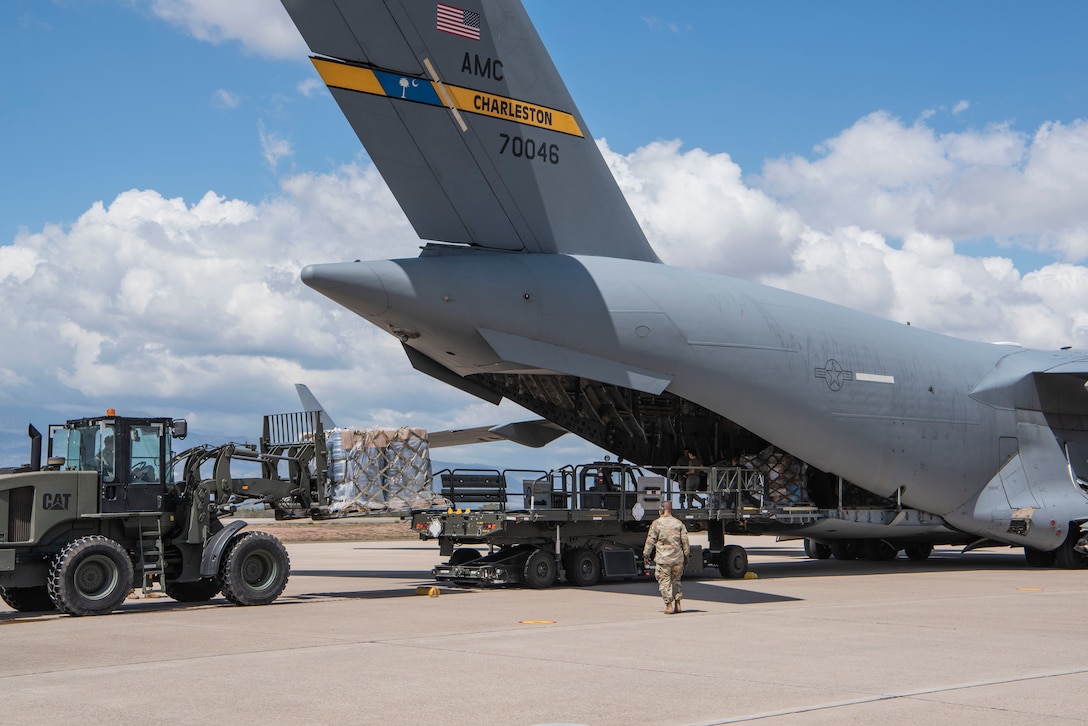 At Soto Cano Air Base, Honduras, U.S. Air Force aerial porters offload over 27 tons of donated humanitarian cargo from the rear of a C-17 Globemaster III aircraft from Joint Base Charleston, S.C., Feb. 13, 2022. Air Force Reserve Citizen Airmen from the 315th Airlift Wing delivered the cargo to Soto Cano as part of a combined crew training and humanitarian delivery mission. (U.S. Air Force photo by Lt. Col. Wayne Capps)