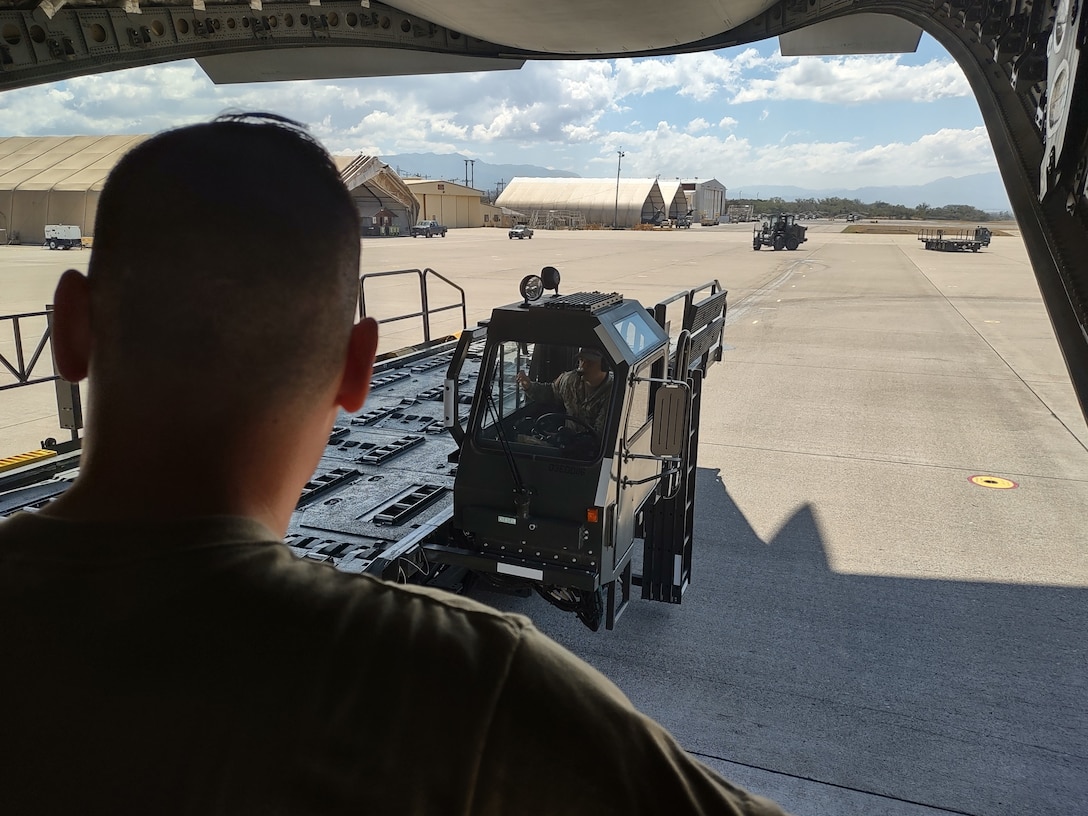 At Soto Cano Air Base, Honduras, U.S. Air Force aerial porters offload over 27 tons of donated humanitarian cargo from the rear of a C-17 Globemaster III aircraft from Joint Base Charleston, S.C., Feb. 13, 2022. Air Force Reserve Citizen Airmen from the 315th Airlift Wing delivered the cargo to Soto Cano as part of a combined crew training and humanitarian delivery mission, helping to stay current on all aircrew training requirements while also assisting a humanitarian cause. (U.S. Air Force photo by Capt. Justin Clark)