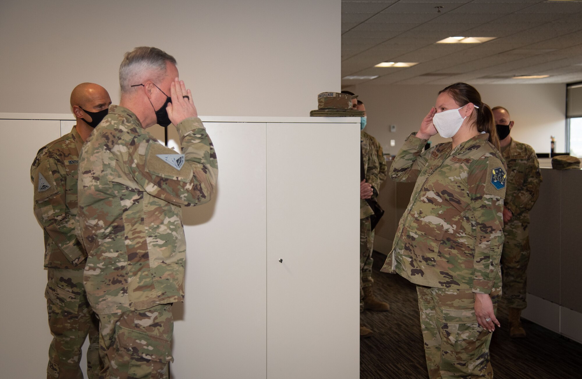 A female Airman salutes a Male Airman After being coined