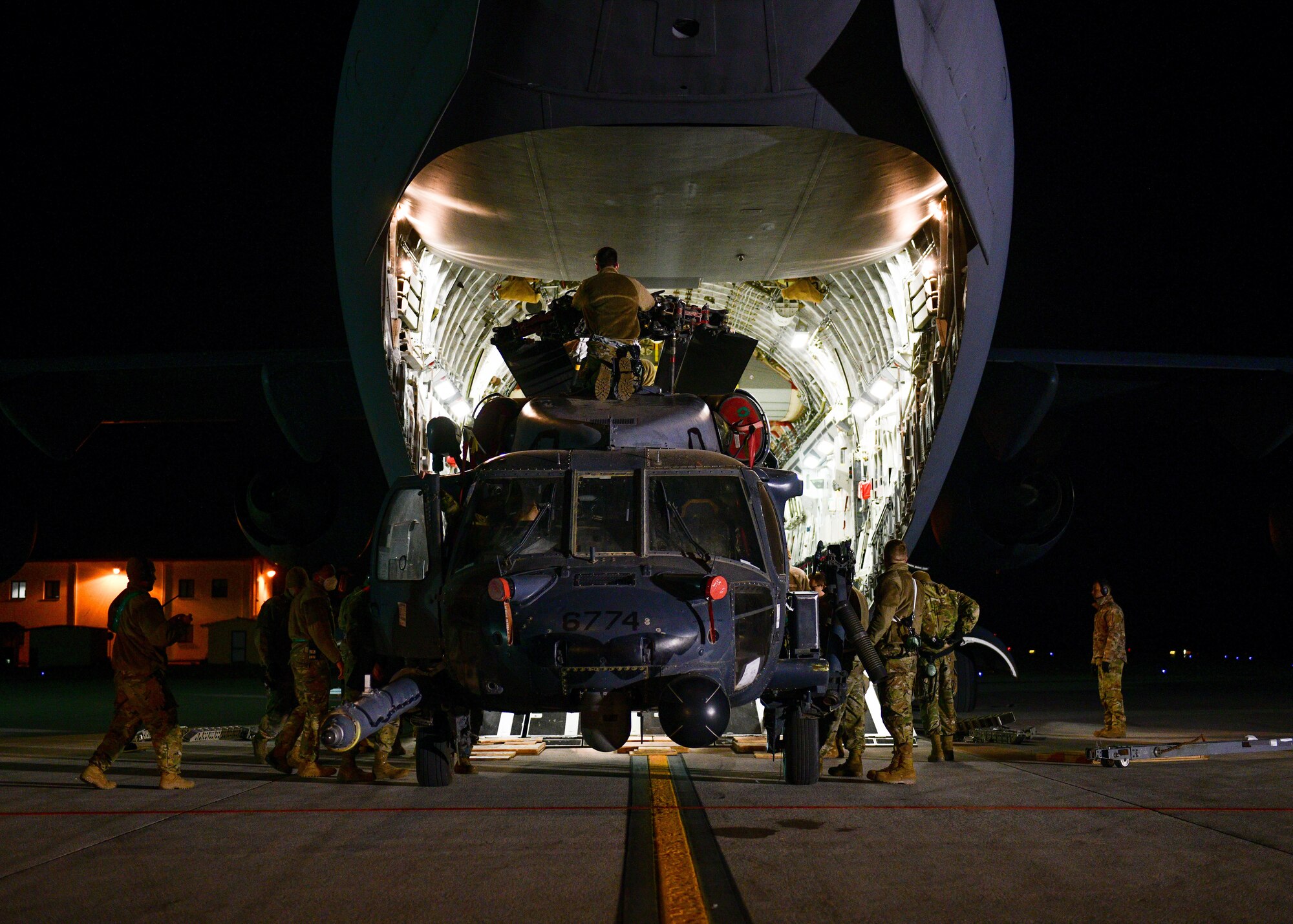 U.S. Airmen assigned to the 724th Air Mobility Squadron unload an HH-60G Pave Hawk from a C-17 Globemaster at Aviano Air Base, Italy, Feb. 9, 2022. The HH-60G was deployed and supported operations with the 56th RQS. The 56th RQS offers long-range rescue, humanitarian assistance, non-combatant evacuation and disaster relief capabilities for USEUCOM, USAFRICOM and NATO in peacetime, contingency and wartime operations. (U.S. Air Force photo by Senior Airman Brooke Moeder)