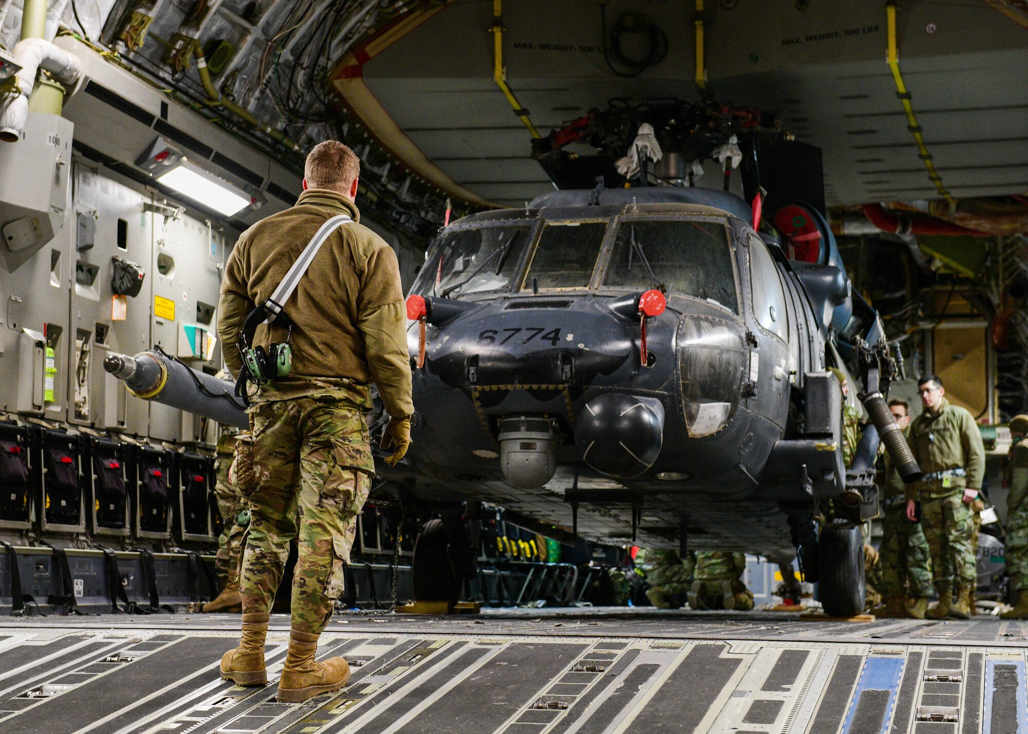 A U.S. Air Force Airman assigned to the 724th Air Mobility Squadron prepares to unload an HH-60G Pave Hawk assigned to the 56th Rescue Squadron from a C-17 Globemaster at Aviano Air Base, Italy, Feb. 9, 2022. The HH-60G returned from a deployment with the 56th RQS and 56th Helicopter Maintenance Unit. The primary mission of the HH-60G is to conduct day or night personnel recovery operations into hostile environments to recover isolated personnel during war. (U.S. Air Force photo by Senior Airman Brooke Moeder)