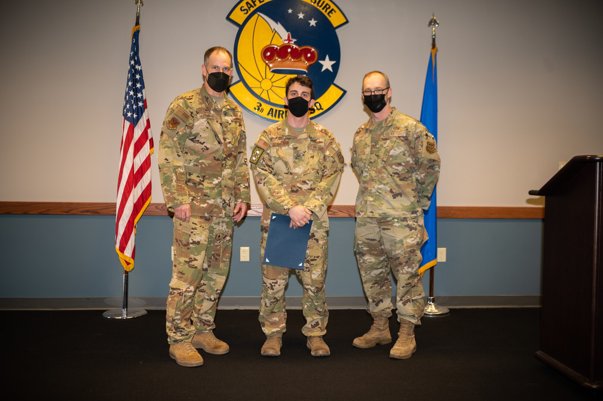 Col. Matt Husemann, left, 436th Airlift Wing commander, and Chief Master Sgt. Timothy Bayes, right, 436th AW command chief, present Tech. Sgt. James Guardiano, 3rd Airlift Squadron noncommissioned officer in charge of scheduling, with a certificate as the week’s Top Performer at Dover Air Force Base, Delaware, Feb. 4, 2022. Guardiano was also coined by Husemann and Bayes for outstanding performance. (U.S. Air Force photo by Mauricio Campino)