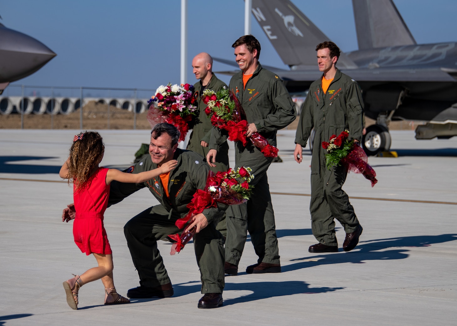 Cmdr. Mark Cochran, left, commanding officer of Strike Fighter Squadron (VFA) 147, is welcomed home by family at Naval Air Station Lemoore, Calif.