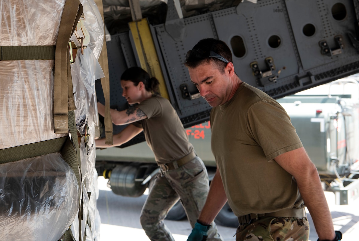 Senior Airman Oana Patrut and Master Sgt. Javier Lopez, loadmasters with Joint Base Charleston's Air Force Reserve 317th Airlift Squadron, offload palletized medical supplies and food from the rear of a C-17 Globemaster III cargo aircraft at Soto Cano Air Base, Honduras, during a combined aircrew training and humanitarian delivery mission, Feb. 13, 2022. The cargo was donated by charities within the U.S. and was transported as part of the Denton Cargo Program, which allows for humanitarian goods to be transported aboard U.S. military aircraft on a space-available basis. (U.S. Air Force photo by Lt. Col. Wayne Capps)