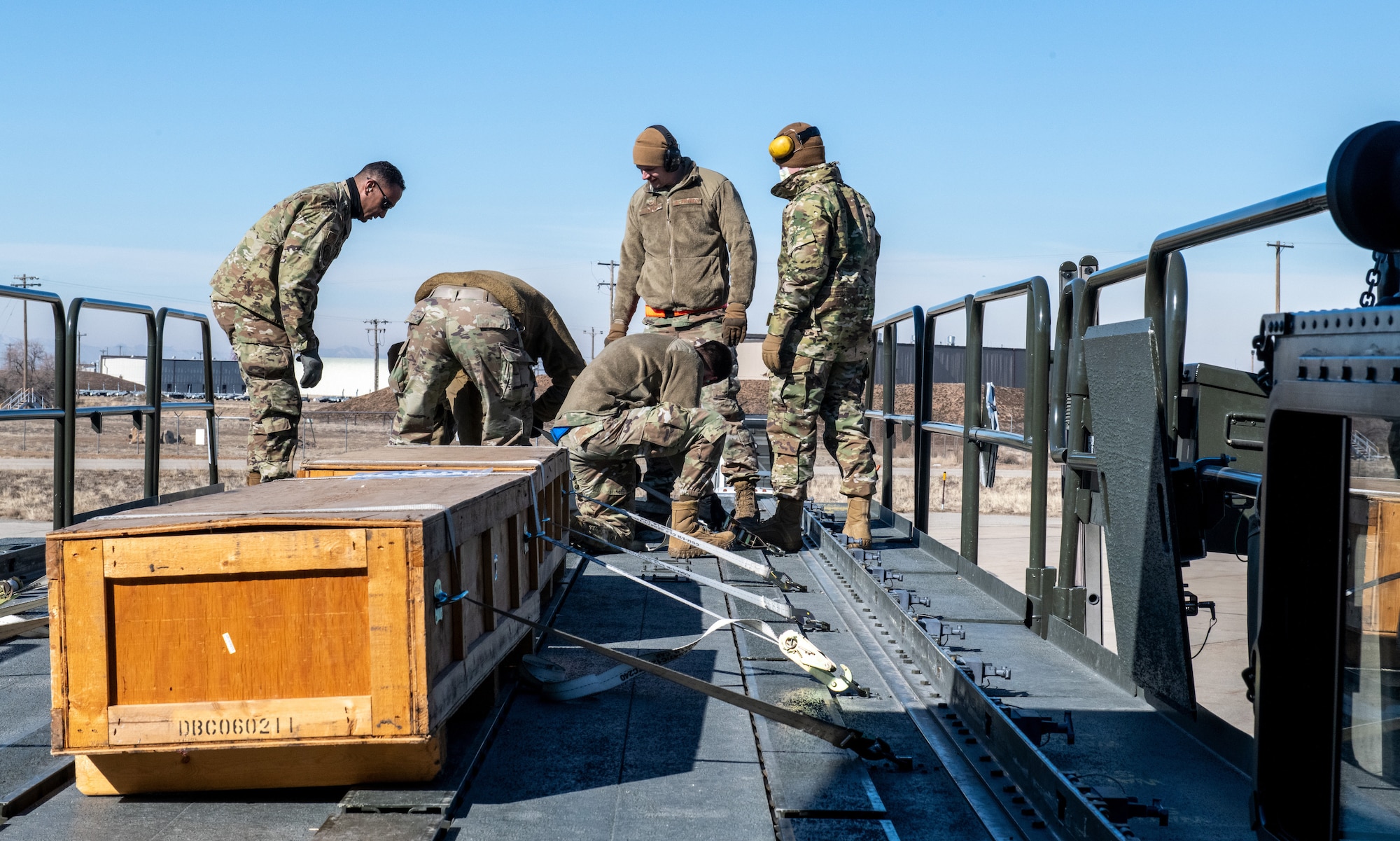 Air Force reservists from the 67th Aerial Port Squadron secure empty casket boxes to a cargo transport during a loading exercise Feb. 5