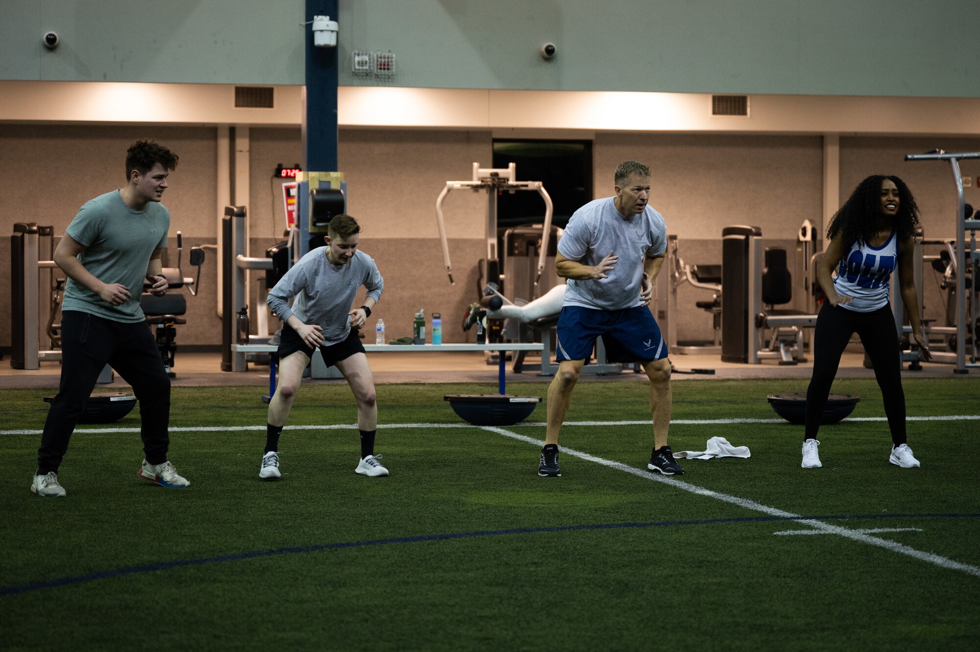 U.S. Air Force Chief Master Sgt. John Lokken, 354th Fighter Wing (FW) command chief (second from right), participates in an exercise with Airmen assigned to the 354th FW and a National Football League (NFL) cheerleader during Pro Blitz Alaska on Eielson Air Force Base, Alaska, Feb. 11, 2022.