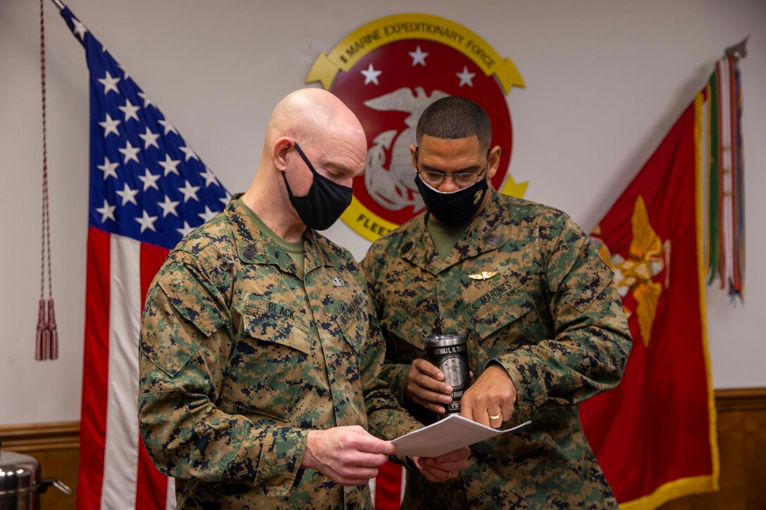 U.S. Marine Corps Sgt. Maj. Troy E. Black, the 19th Sergeant Major of the Marine Corps, speaks to Sgt. Maj. Lonnie Travis, the II Marine Expeditionary Force sergeant major, before a II MEF overview given by the commanding general, Lt. Gen. William Jurney, at Camp Lejeune, North Carolina, Jan. 11, 2022. The brief was part of a three-day Sergeant Major of the Marine Corps Force Level Summit. The summits are held quarterly to support force level sergeants major at their respective commands. (U.S. Marine Corps photo by Sgt. Victoria Ross)