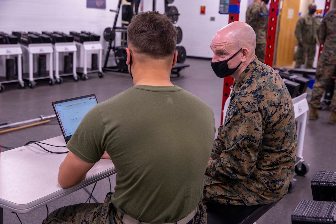 U.S. Marine Corps Sgt. Maj. Troy E. Black, the 19th Sergeant Major of the Marine Corps, speaks to Pfc. Kais Asefi during a human performance demonstration at the School of Infantry-East, Camp Lejeune, North Carolina, Jan. 11, 2022. The brief was part of a three-day Sergeant Major of the Marine Corps Force Level Summit. The summits are held quarterly to support force level sergeants major at their respective commands. (U.S. Marine Corps photo by Sgt. Victoria Ross)