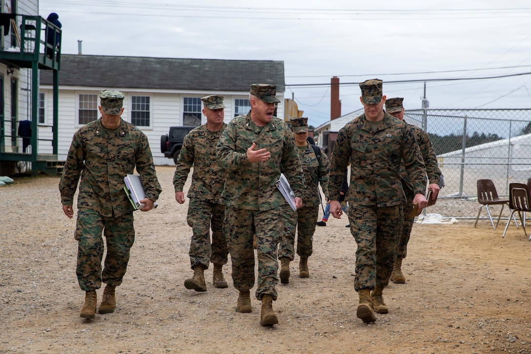 Senior Marine leaders walk and talk during a tour of the expeditionary housing at Fort Pickett.
