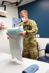 A soldier puts a pillow case on a pillow