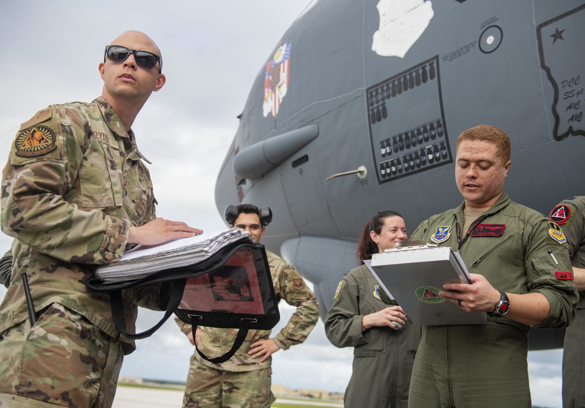 U.S. Air Force Tech Sgt. Alex Covert, 96th Expeditionary Bomb Squadron flight line expediter (left), and Capt. Kason Pifer, 96th EBS pilot (right), review post-flight forms during a Bomber Task Force mission at Andersen Air Force Base, Guam, Feb. 11, 2022. These bomber missions are representative of the U.S. commitment to our allies and enhancing regional security. (U.S. Air Force photo by Staff Sgt. Lawrence Sena)