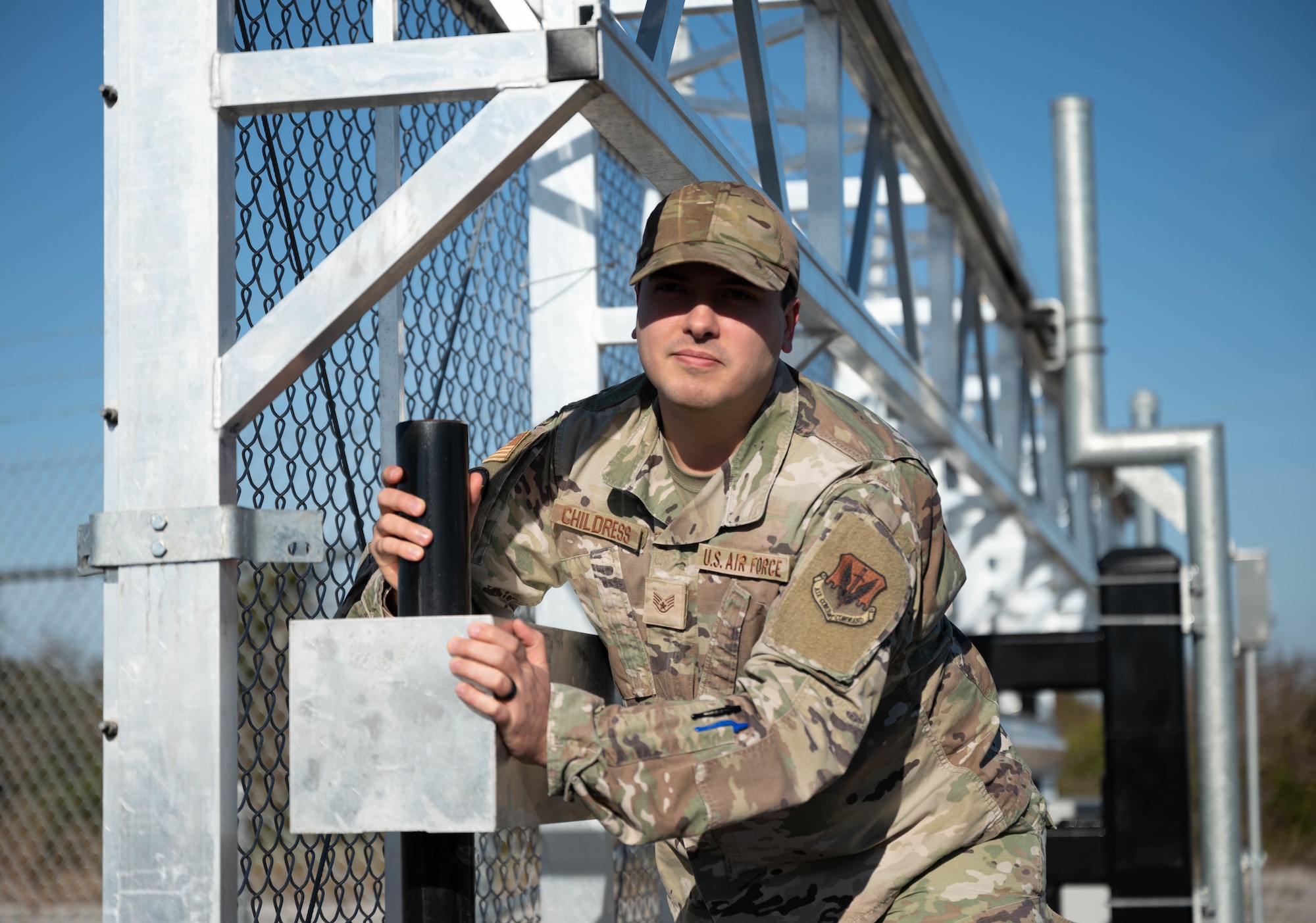 An Airman pushes a gate closed
