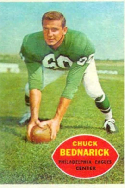A football player poses with a football on a sports card.