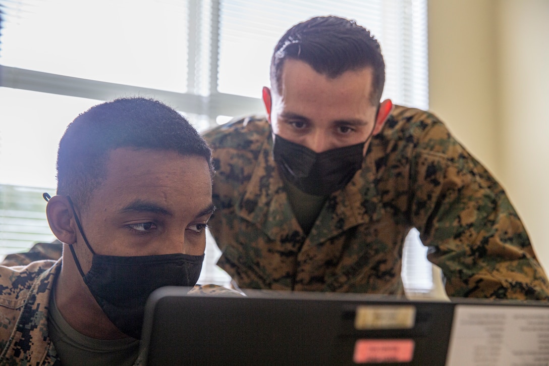 U.S. Marine Corps Cpl. Brian King-Hamilton, left, a financial management resource analyst with Marine Wing Headquarters Squadron 1, 1st Marine Aircraft Wing, reviews tax documents with Sgt. Chyler Corona, the noncommissioned officer in charge with the Camp Foster Tax Center, Headquarters and Support Battalion, Marine Corps Installations Pacific, at the Camp Foster Tax Center on Camp Foster, Okinawa, Japan, Feb. 10, 2022. The Camp Foster Tax Center assists eligible taxpayers with the preparation of e-filing both federal income tax returns and state income tax returns, as applicable. The team at the Tax Center not only assists service members of any branch, but also any eligible taxpayer that has base access, including but not limited to retired service members aboard Okinawa, dependents, and status of forces agreement personnel. (U.S. Marine Corps photo by Lance Cpl. Alex Fairchild)