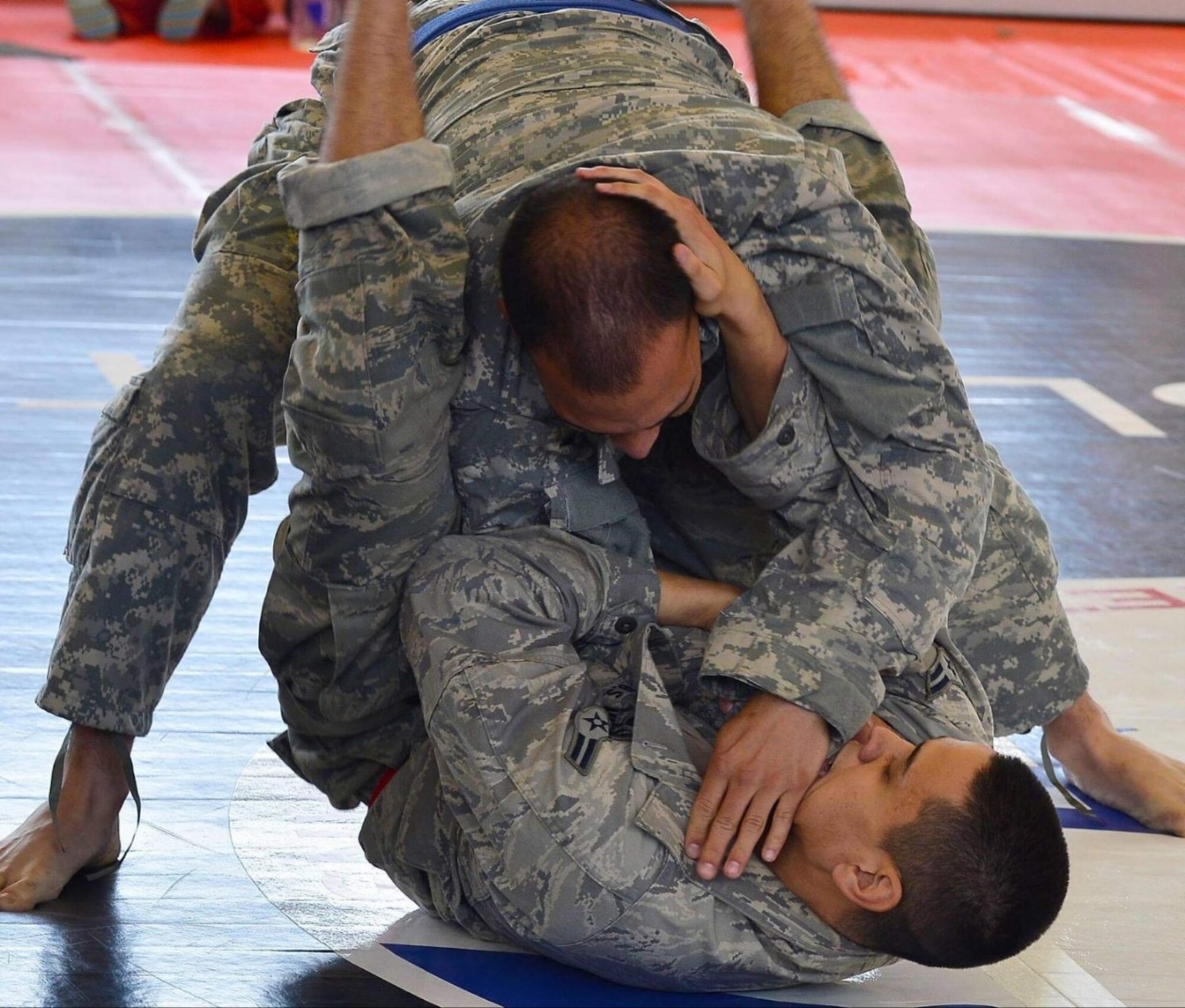 Airmen 1st Class Kazuhito Ikematsu, 1st Combat Communications Squadron radio frequency transmissions technician, attempts a triangle choke hold during a combatives tournament, Sept. 7, 2013. Kleber Kaserne Fitness Center, Germany. (U.S. Air Force photo/Airman Dymekre Allen)