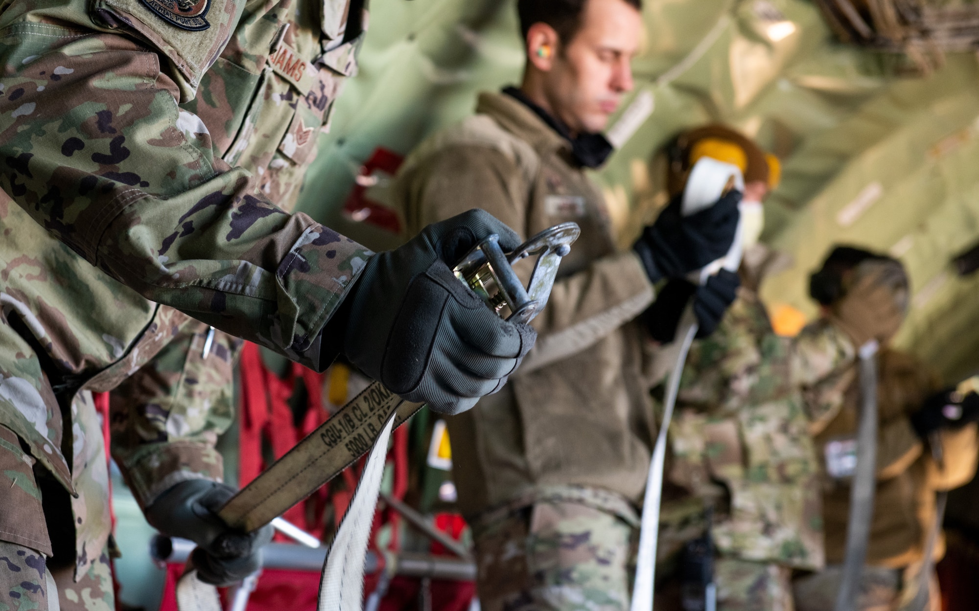 Air Force reservists from the 67th Aerial Port Squadron roll up cargo straps during a loading exercise Feb. 5, 2022 at Hill Air Force Base, Utah