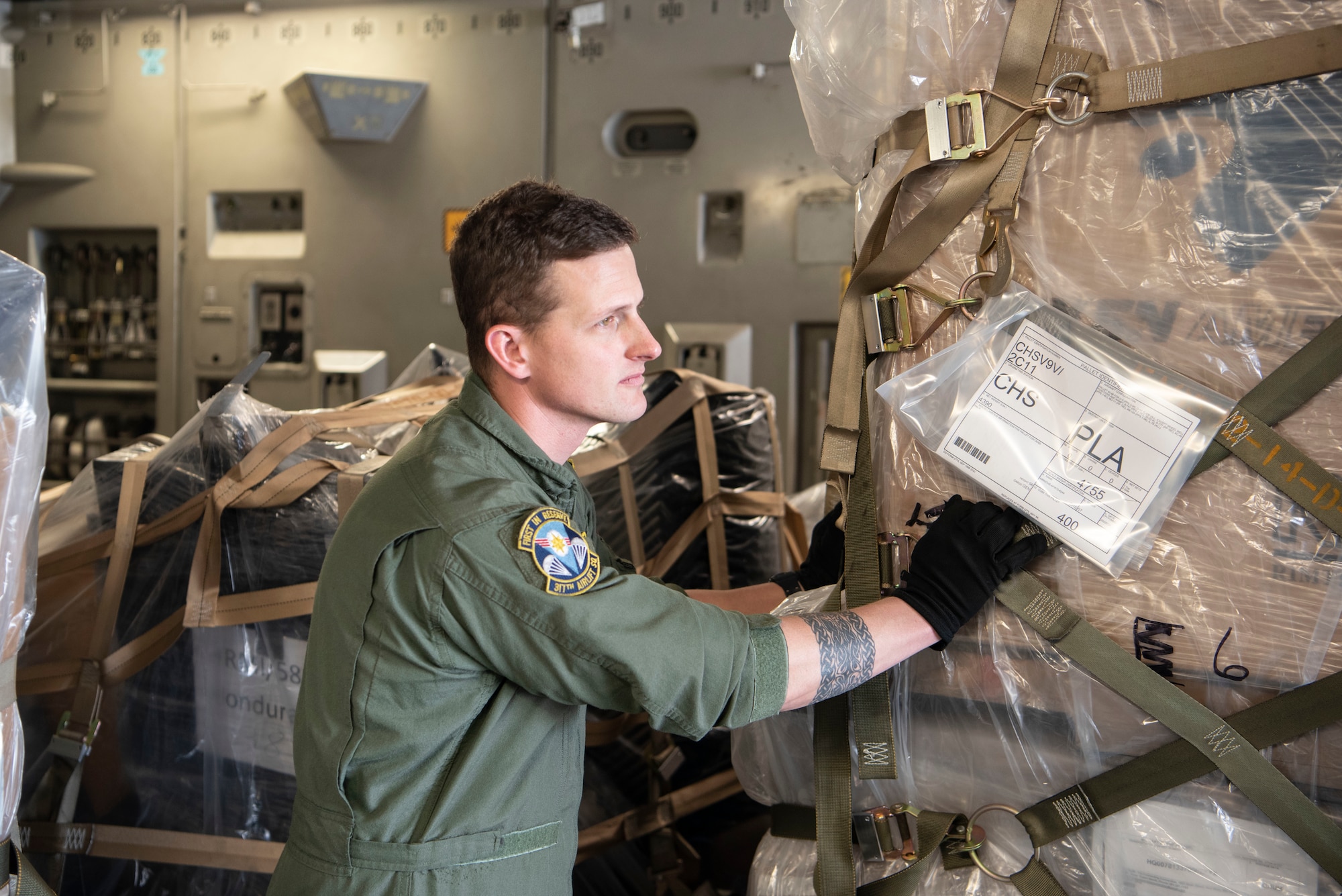 Tech. Sgt. Scott Guerin, loadmaster with Joint Base Charleston's 317th Airlift Squadron, assists with offloading donated humanitarian cargo from the rear of a C-17 Globemaster III aircraft at Soto Cano Air Base, Honduras, Feb. 13, 2022. Guerin, an Air Force Reservist, successfully completed a loadmaster checkride during the combined training and humanitarian mission, and so is requalified as a loadmaster for the next 17 months. (U.S. Air Force photo by Lt. Col. Wayne Capps)