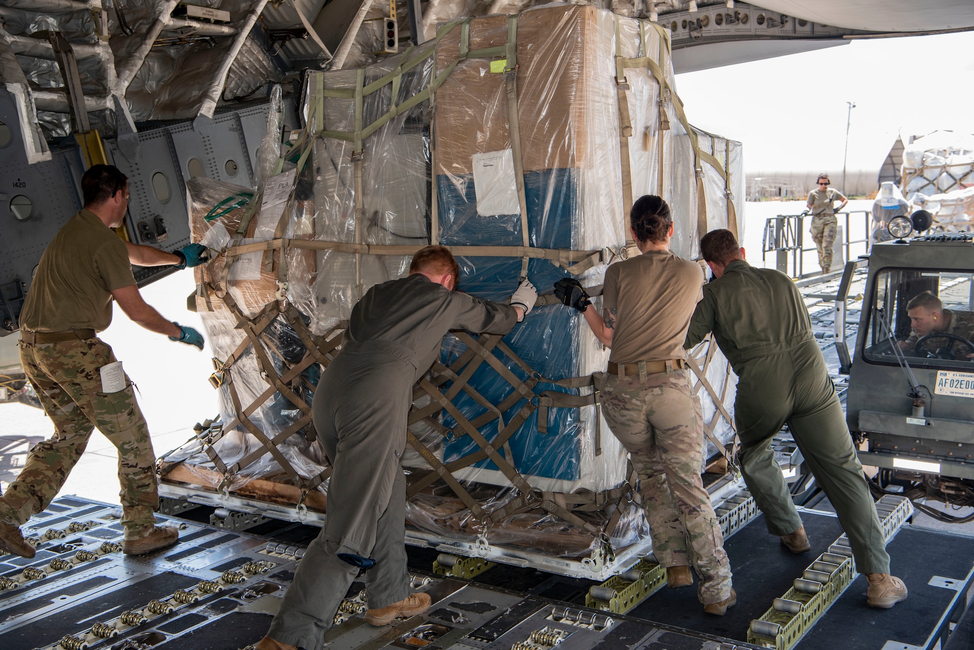 Air Force Reserve aircrew members offload donated food and medical equipment from the rear of a C-17 Globemaster III aircraft at Soto Cano Air Base, Honduras, as part of a weekend combined aircrew training and humanitarian delivery mission in Central America, Feb. 13, 2022. Reserve Citizen Airmen from Joint Base Charleston’s 315th Airlift Wing flew in over 54,000 pounds of donated cargo to the base, all of which is destined for distribution by local charities. (U.S. Air Force photo by Lt. Col. Wayne Capps)