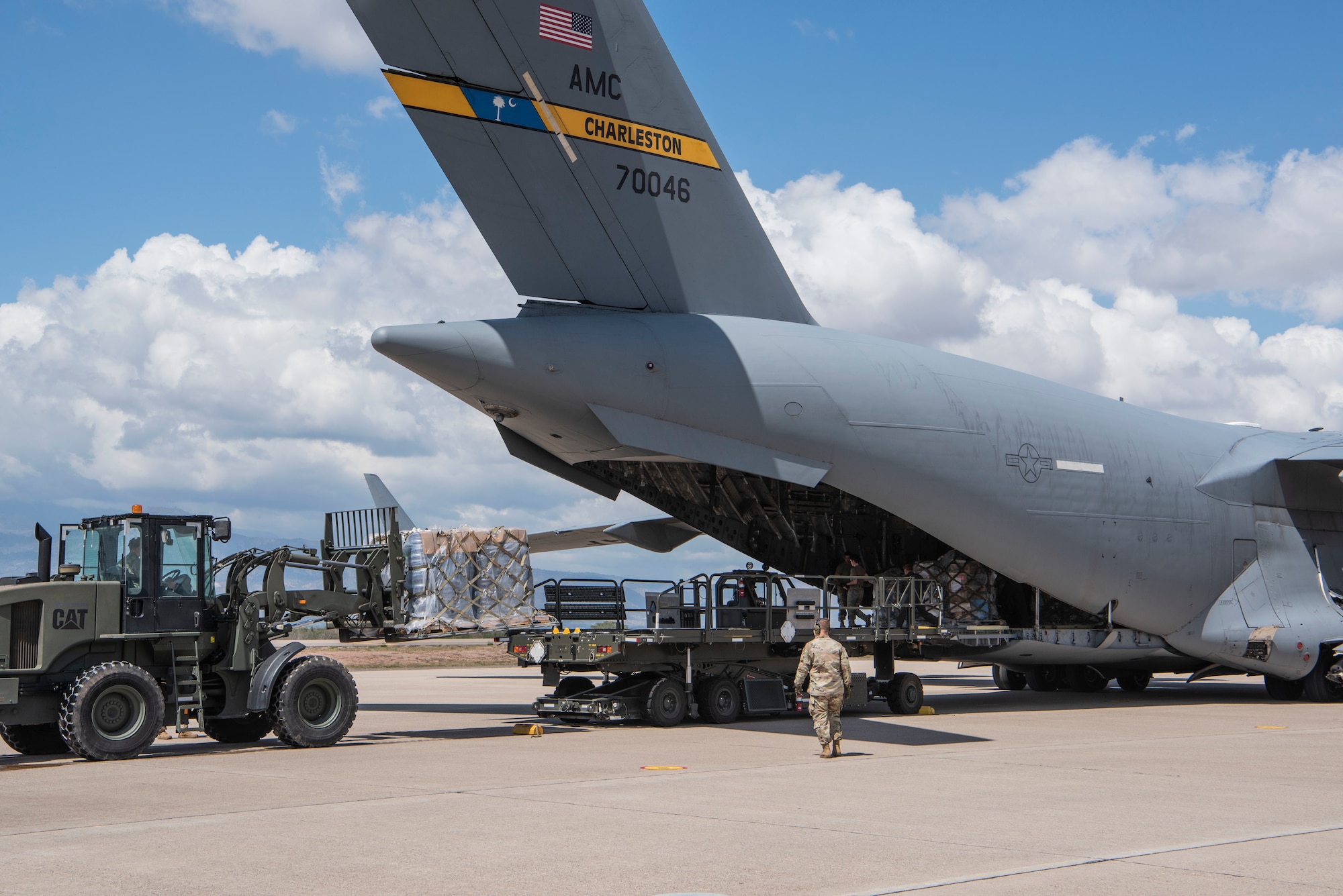 At Soto Cano Air Base, Honduras, U.S. Air Force aerial porters offload over 27 tons of donated humanitarian cargo from the rear of a C-17 Globemaster III aircraft from Joint Base Charleston, S.C., Feb. 13, 2022. Air Force Reserve Citizen Airmen from the 315th Airlift Wing delivered the cargo to Soto Cano as part of a combined crew training and humanitarian delivery mission. (U.S. Air Force photo by Lt. Col. Wayne Capps)