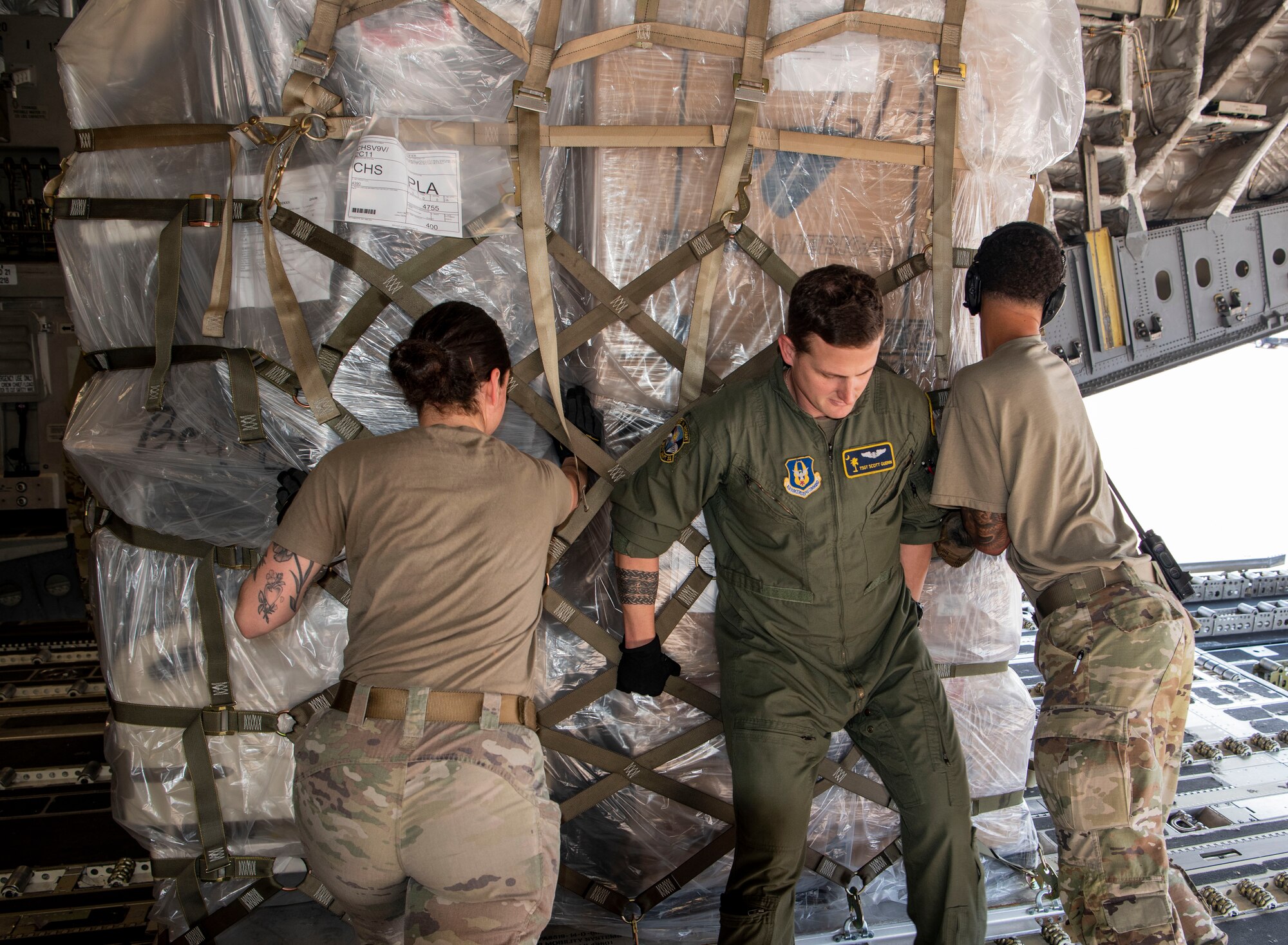 Air Force Reserve aircrew members offload donated food and medical equipment from the rear of a C-17 Globemaster III aircraft at Soto Cano Air Base, Honduras, as part of a weekend combined aircrew training and humanitarian delivery mission in Central America, Feb. 13, 2022. Reserve Citizen Airmen from Joint Base Charleston’s 315th Airlift Wing flew in over 54,000 pounds of donated cargo to the base, all of which is destined for distribution by local Honduran charities. (U.S. Air Force photo by Lt. Col. Wayne Capps)