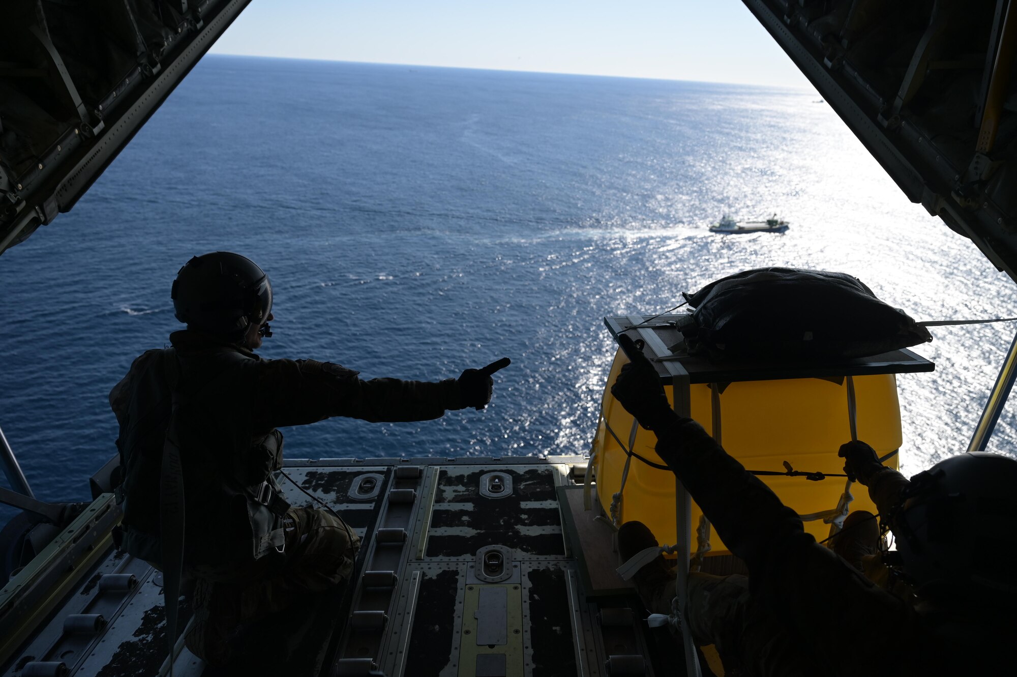 Staff. Sgt. Wesley Zech, left, and Staff Sgt. Mcarthur Posey, loadmasters assigned to the 36th Airlift Squadron, countdown a cargo drop aboard a C-130J Super Hercules near the Irozaki Cape, Japan, during exercise Tomodachi Rescue 22 Feb. 11, 2022.