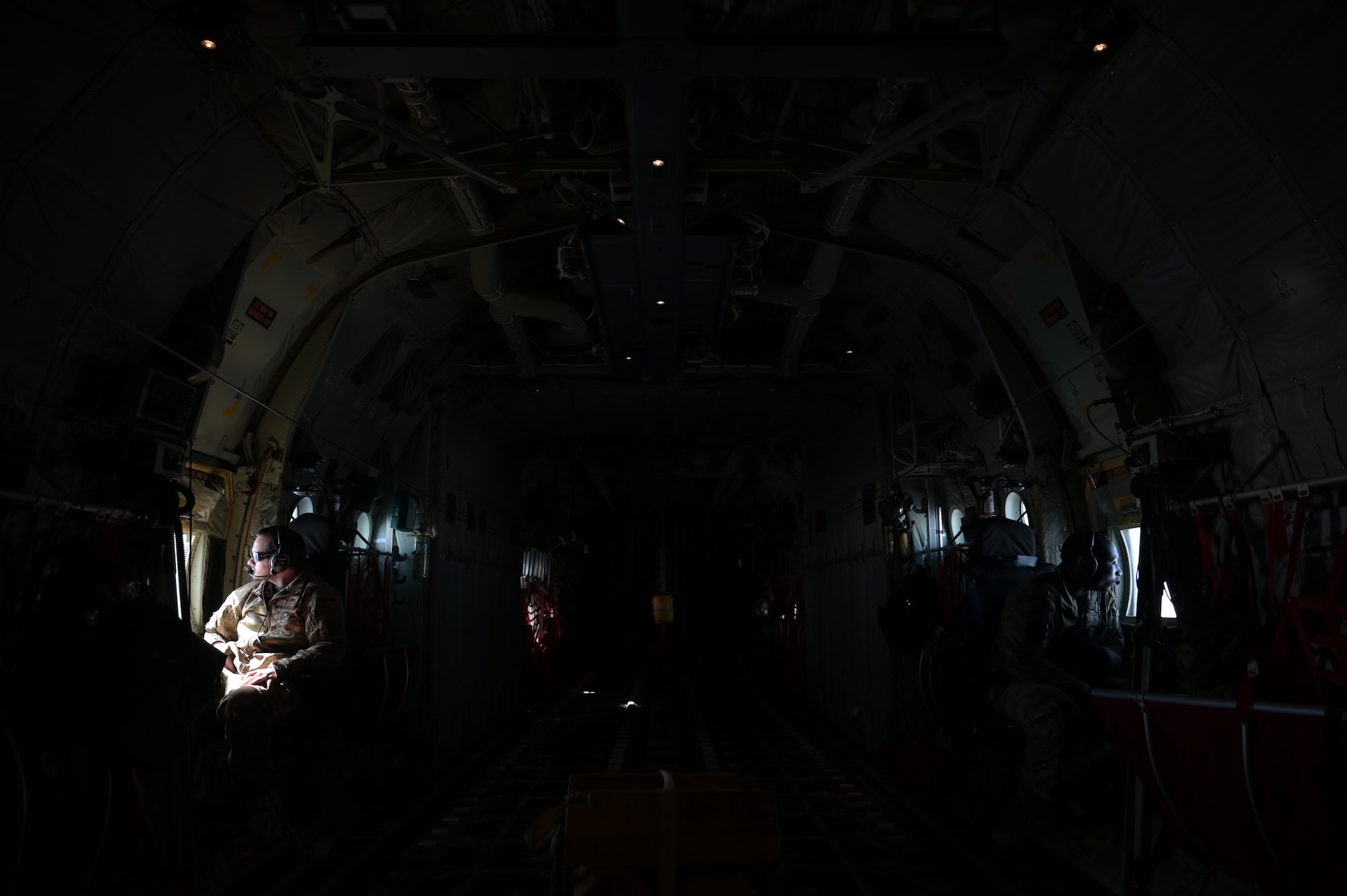 Staff. Sgt. Wesley Zech, left, and Staff Sgt. Mcarthur Posey, loadmasters assigned to the 36th Airlift Squadron, scan the horizon aboard a C-130J Super Hercules near Yokota Air Base, Japan, during exercise Tomodachi Rescue 22 Feb. 11, 2022.