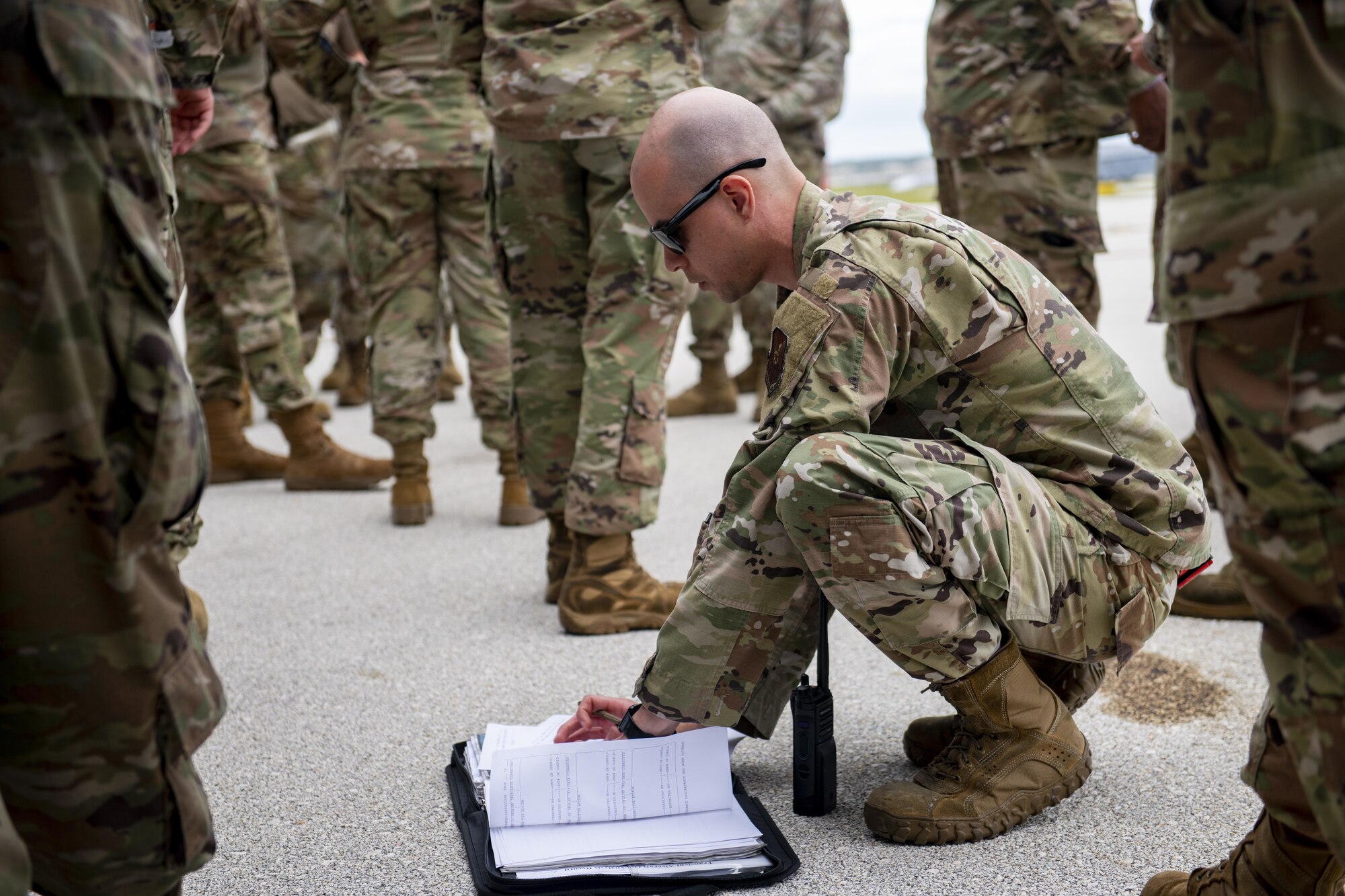 U.S. Air Force Tech. Sgt. Alex Covert, 96th Expeditionary Bomb Squadron flight line expediter, looks over forms following the landing of B-52 Stratofortress aircraft for a Bomber Task Force deployment at Andersen Air Force Base, Guam, Feb. 11, 2022. The U.S. routinely and visibly demonstrates commitment to our allies and partners through the global employment of our military forces in Bomber Task Force missions. (U.S. Air Force photo by Staff Sgt. Lawrence Sena)
