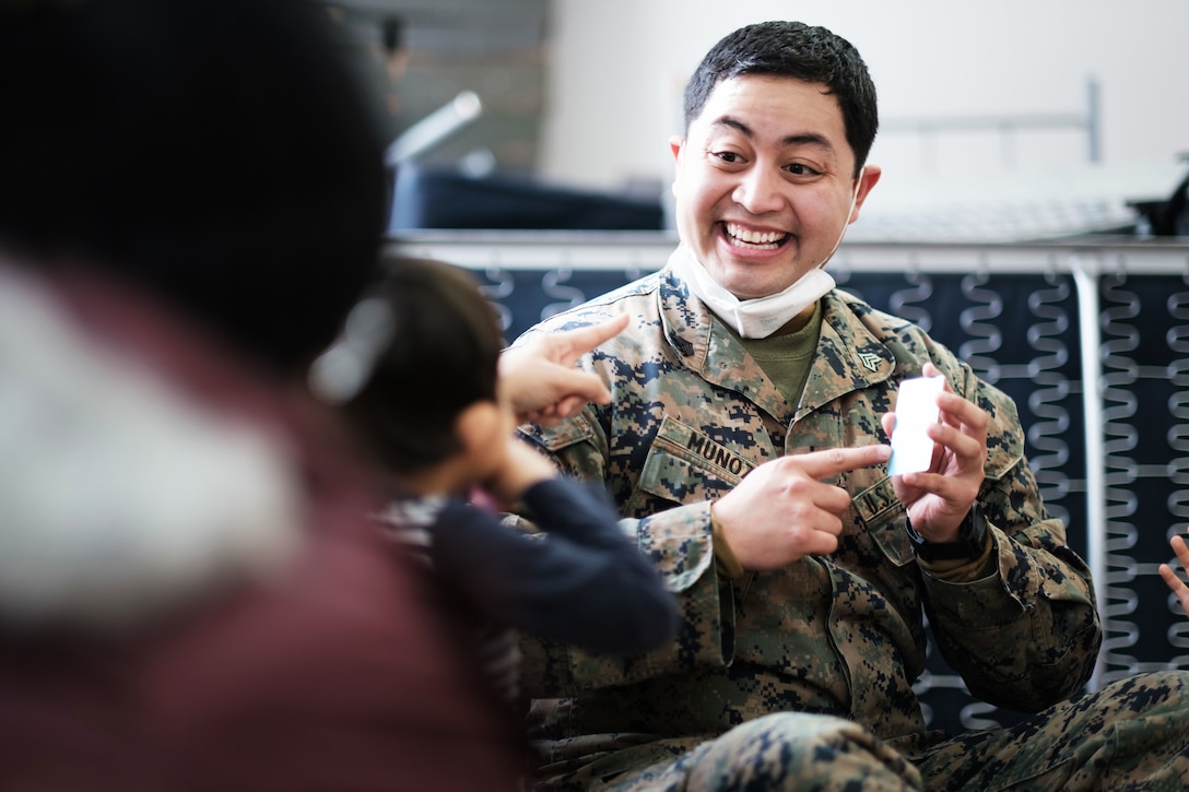 A soldier teaches American Sign Language to a deaf Afghan child.