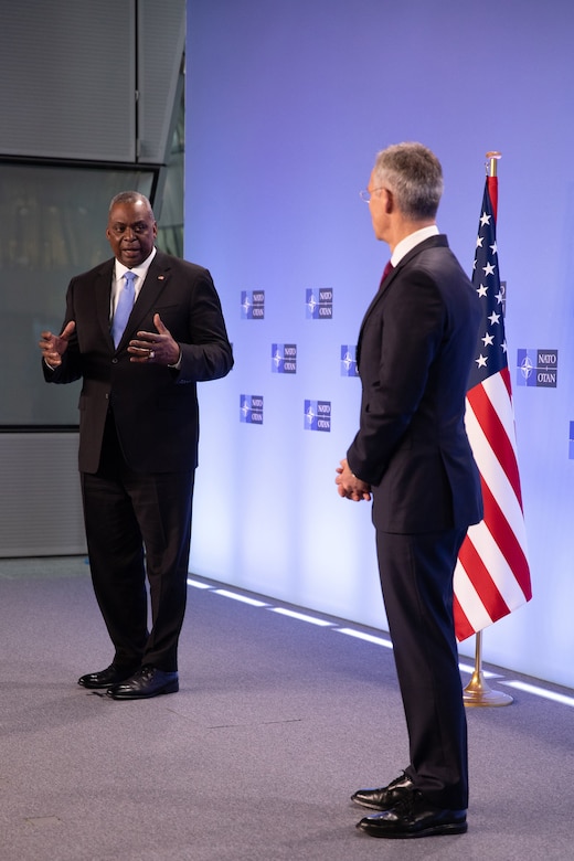 Two men talk to each other on a stage.