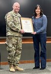 Jessica Sawyer, of Anna, Illinois, accepts a Certificate of Appreciation from husband, Staff Sgt. Phillip Sawyer, 2nd Battalion, 129th Regiment (Regional Training Institute), during his retirement ceremony Feb. 12 at Camp Lincoln, Springfield, Illinois.