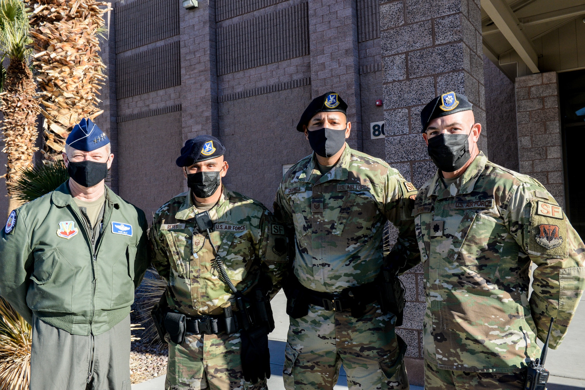 3 Airmen and a general pose outside of a building