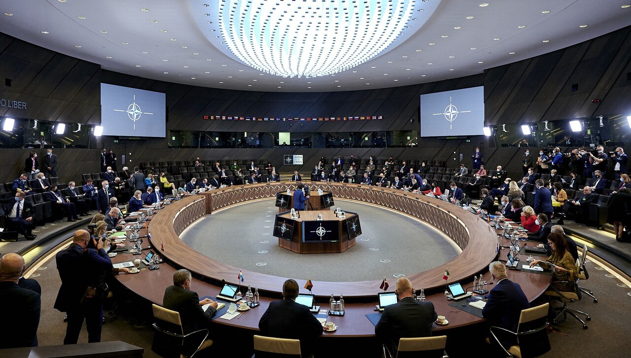 A large group of people sit around a circular table.