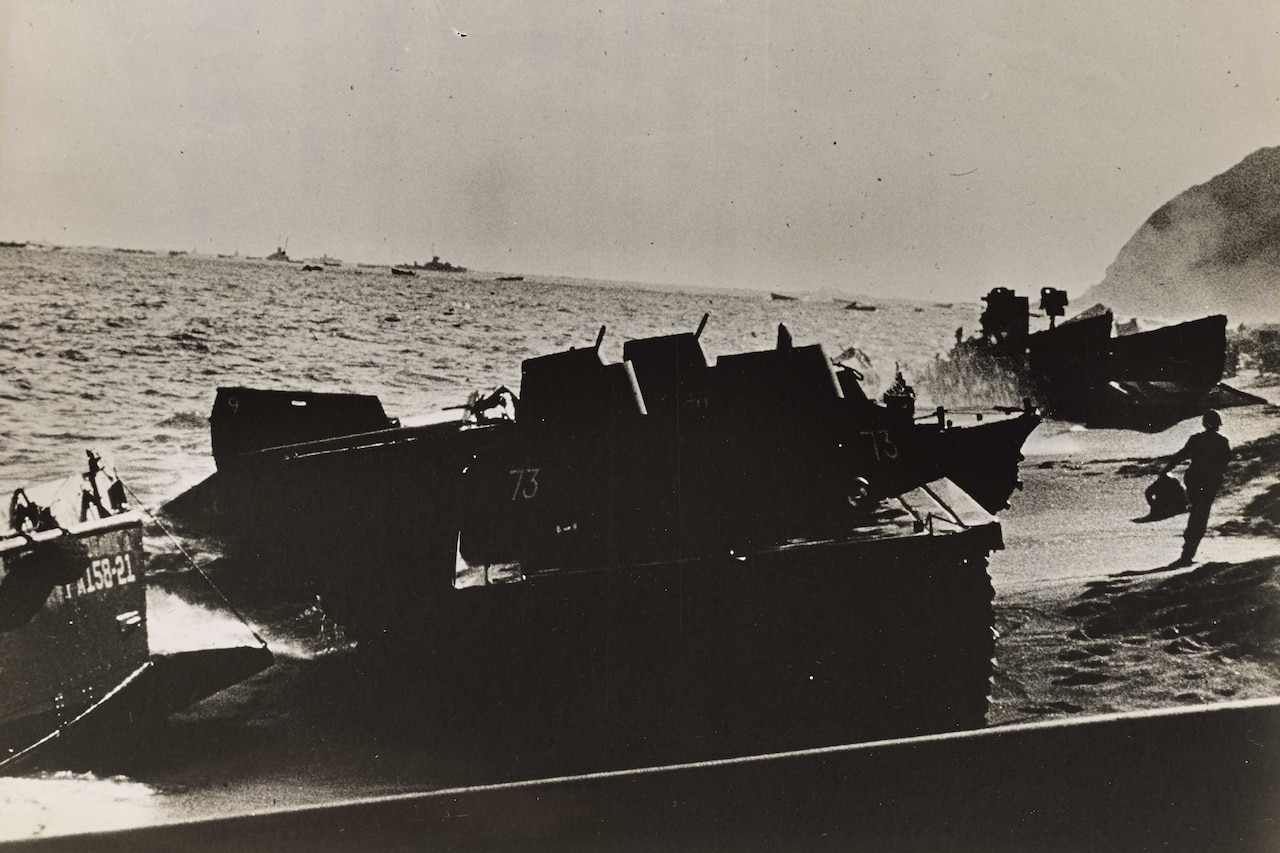A landing craft sits on a beach.