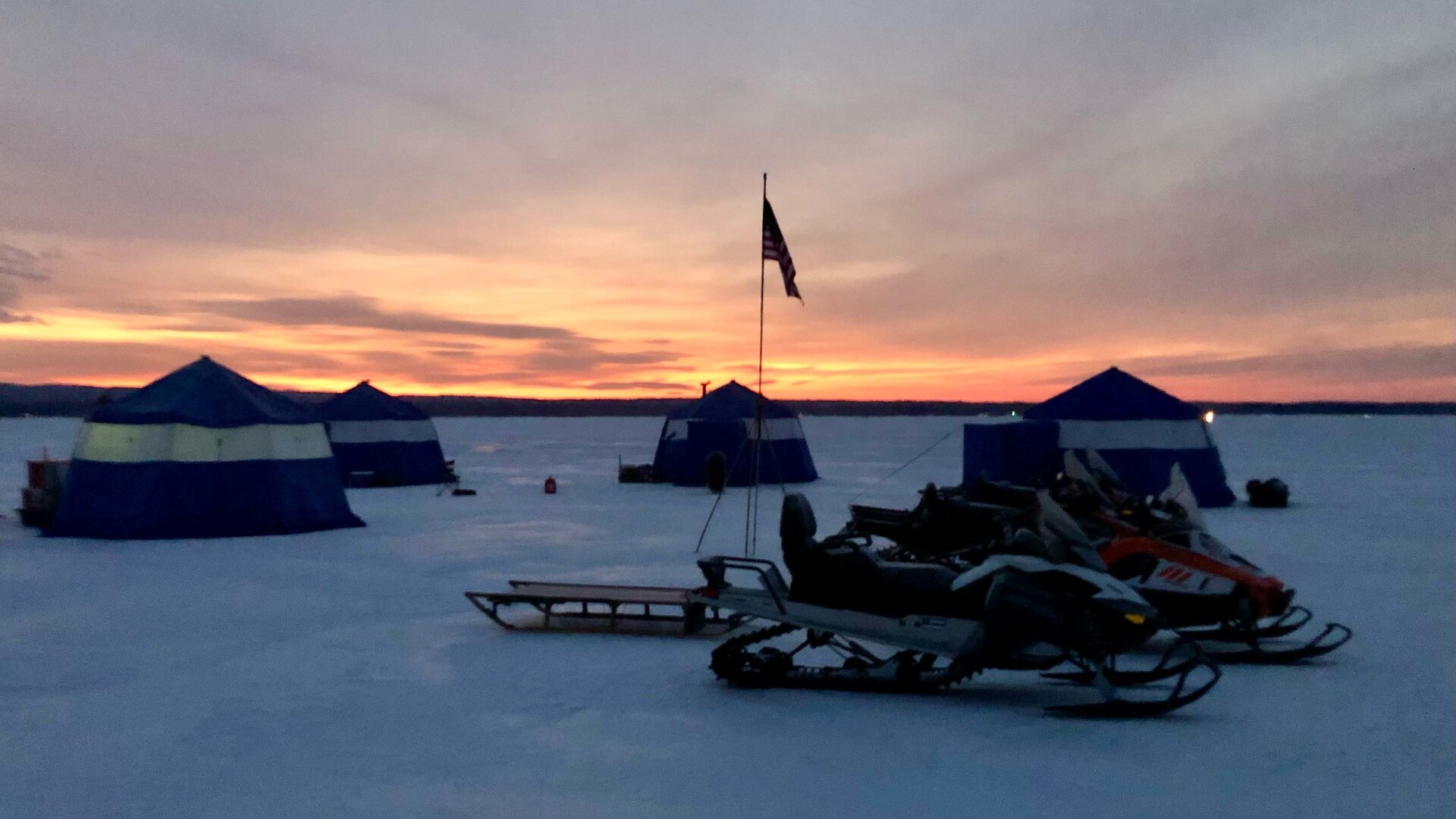 The sun sets over a camp erected on the ice of the Great Sacandaga Lake near Northville, New York, Feb. 15, 2022, by Airmen of the New York Air National Guard's 109th Airlift Wing. The Airmen were training on the tasks involved with creating an ice "ski-way" to land massive ski-equipped LC-130 Hercules aircraft on ice in the polar regions.