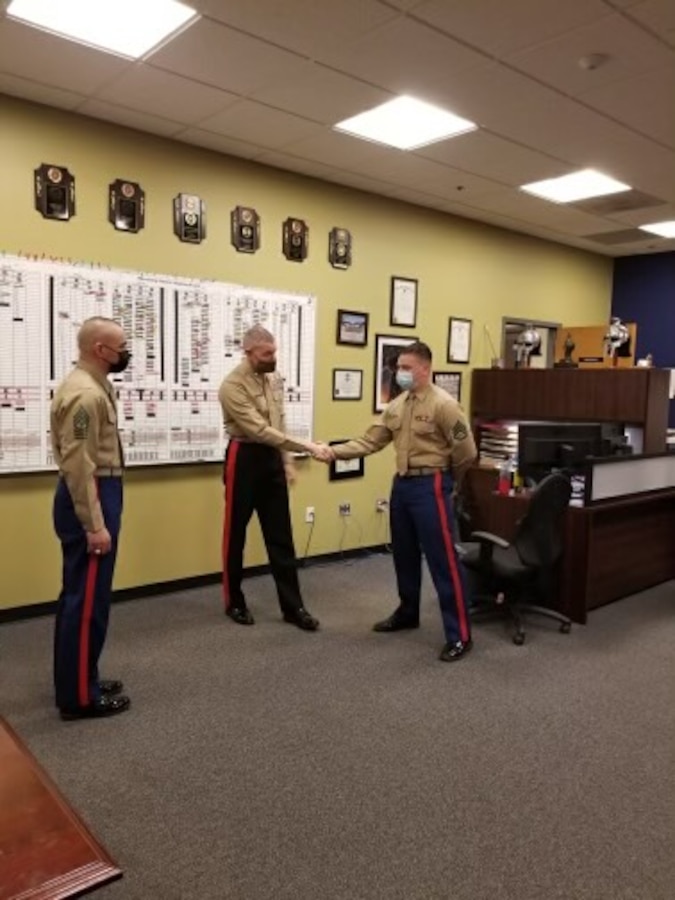U.S. Marine Corps Major Gen. Jason Q. Bohm, and Sgt. Maj. Adan F. Moreno, Marine Corps Recruiting Command, Commanding General and Sergeant Major visit Recruiting Station Lansing, Mich., Feb. 16. Bohm and Moreno award a challenge coin to Staff Sgt. Benjamin, pool specialist, for his continuous efforts to the recruiting force.