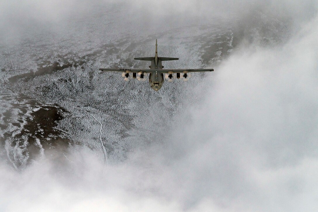 A large military aircraft flies at night.