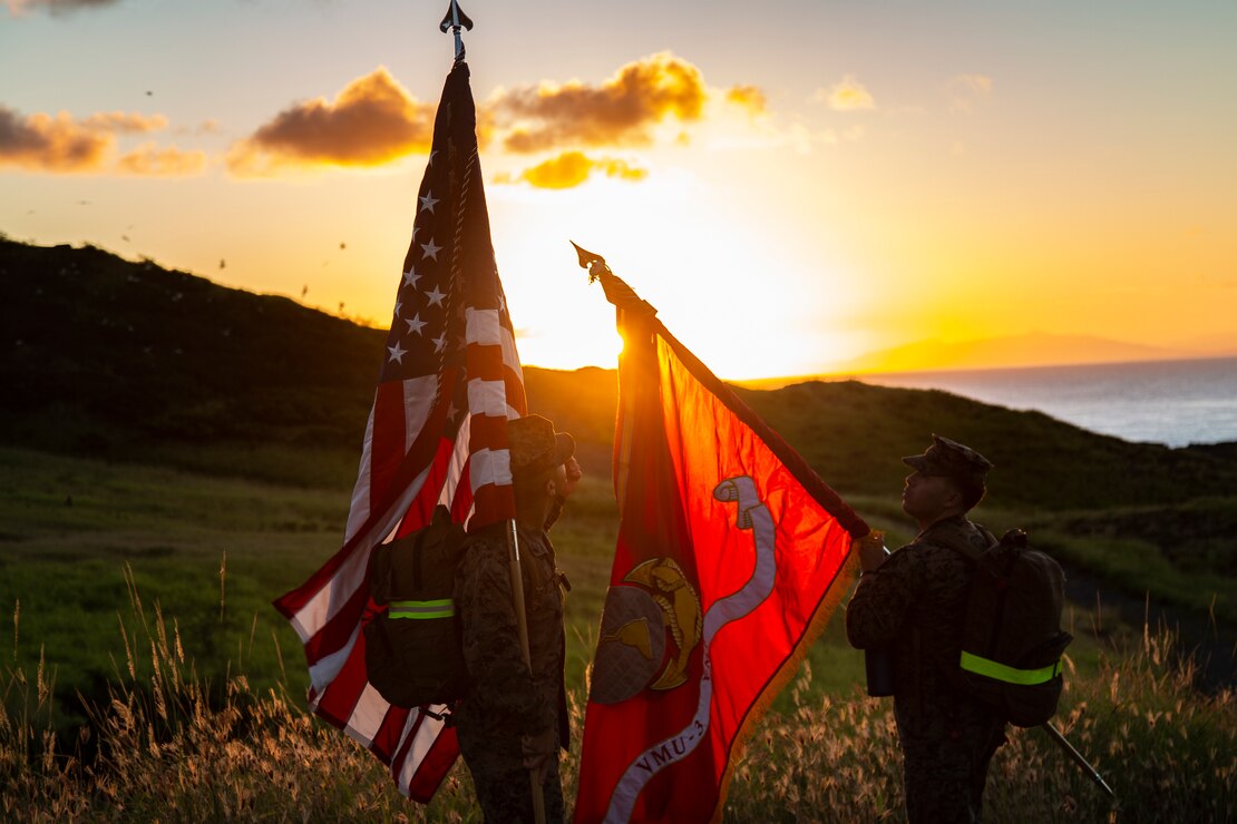 U.S. Marines with Marine Unmanned Aerial Vehicle Squadron (VMU) 3, prepare colors for group photos during a conditioning hike at Marine Corps Base Hawaii, Hawaii, Feb. 11, 2022. VMU-3 conducted the hike to increase physical fitness levels, improve confidence & proficiency of issued gear and build esprit de corps.