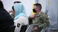 An Afghan evacuee wears a 101st Airborne Division (Air Assault) unit patch during a community council meeting with Task Force McCoy leadership at Fort McCoy, Wisconsin, Nov. 3, 2021. The community council is made up of Afghan evacuee block leaders who meet with Task Force McCoy leadership weekly to ask questions and discuss programs offered to the Afghan personnel here. The Department of Defense, through U.S. Northern Command, and in support of the Department of Homeland Security, is providing transportation, temporary housing, medical screening, and general support for at least 50,000 Afghan evacuees at suitable facilities, in permanent or temporary structures, as quickly as possible. This initiative provides Afghan evacuees essential support at secure locations outside Afghanistan. (U.S. Army photo by Pfc. Caitlin Wilkins, 50th Public Affairs Detachment)