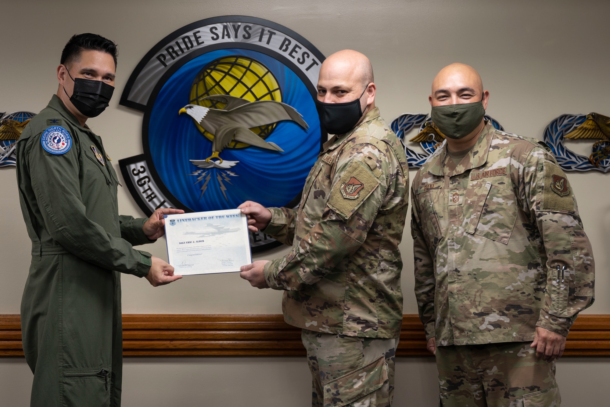 U.S. Air Force Staff Sgt. Eric Alder, noncommissioned officer in charge of fuels facilities with the 36th Logistics Readiness Squadron, receives the Linebacker of the Week award from U.S. Air Force Col. David Aragon, 36th Wing vice commander, and U.S. Air Force Chief Master Sgt. John Payne, 36th Wing command chief, at Andersen Air Force Base, Guam, Feb. 9, 2022.