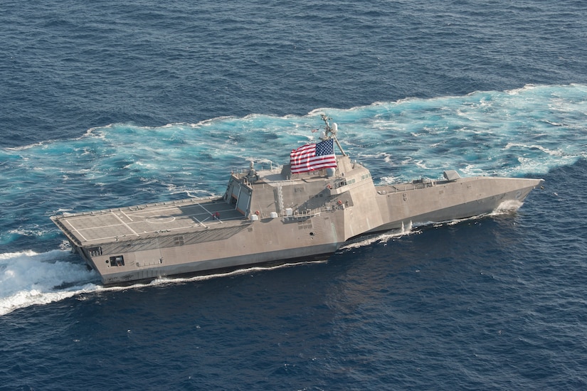 A Navy ship moves through the water.