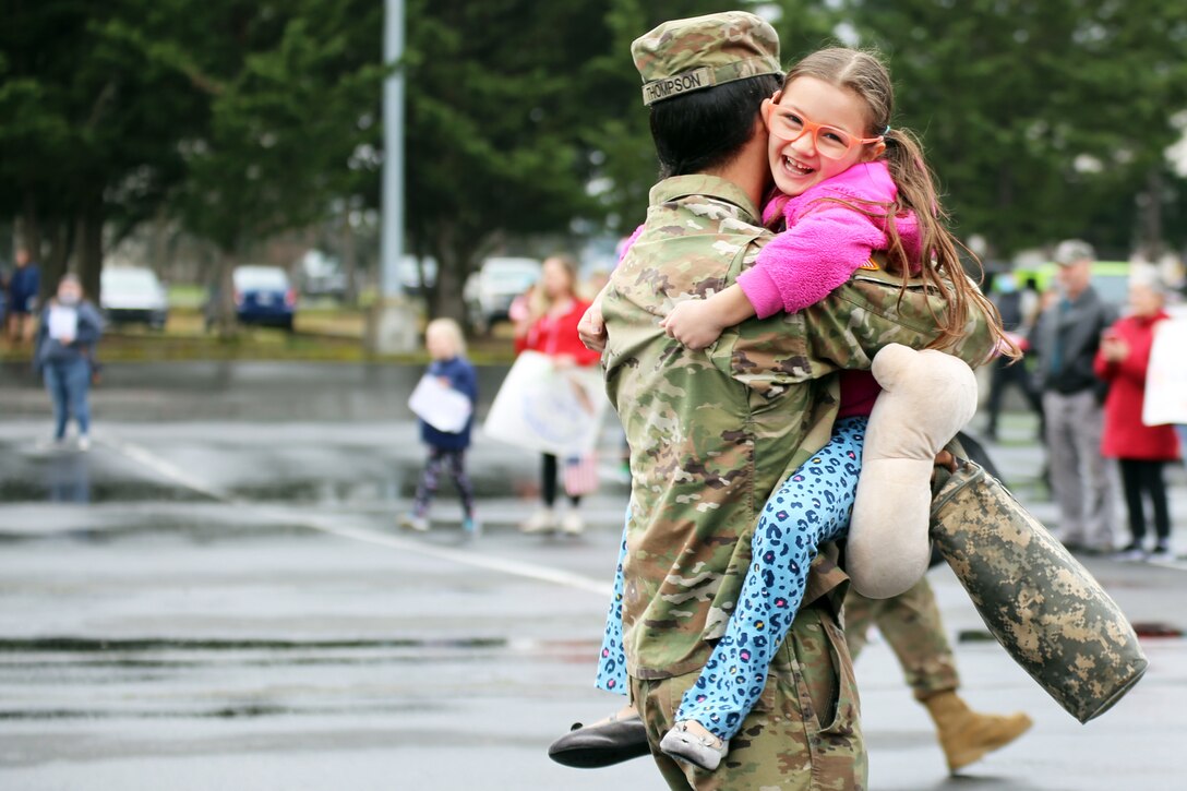 A guardsman embraces and holds a child.