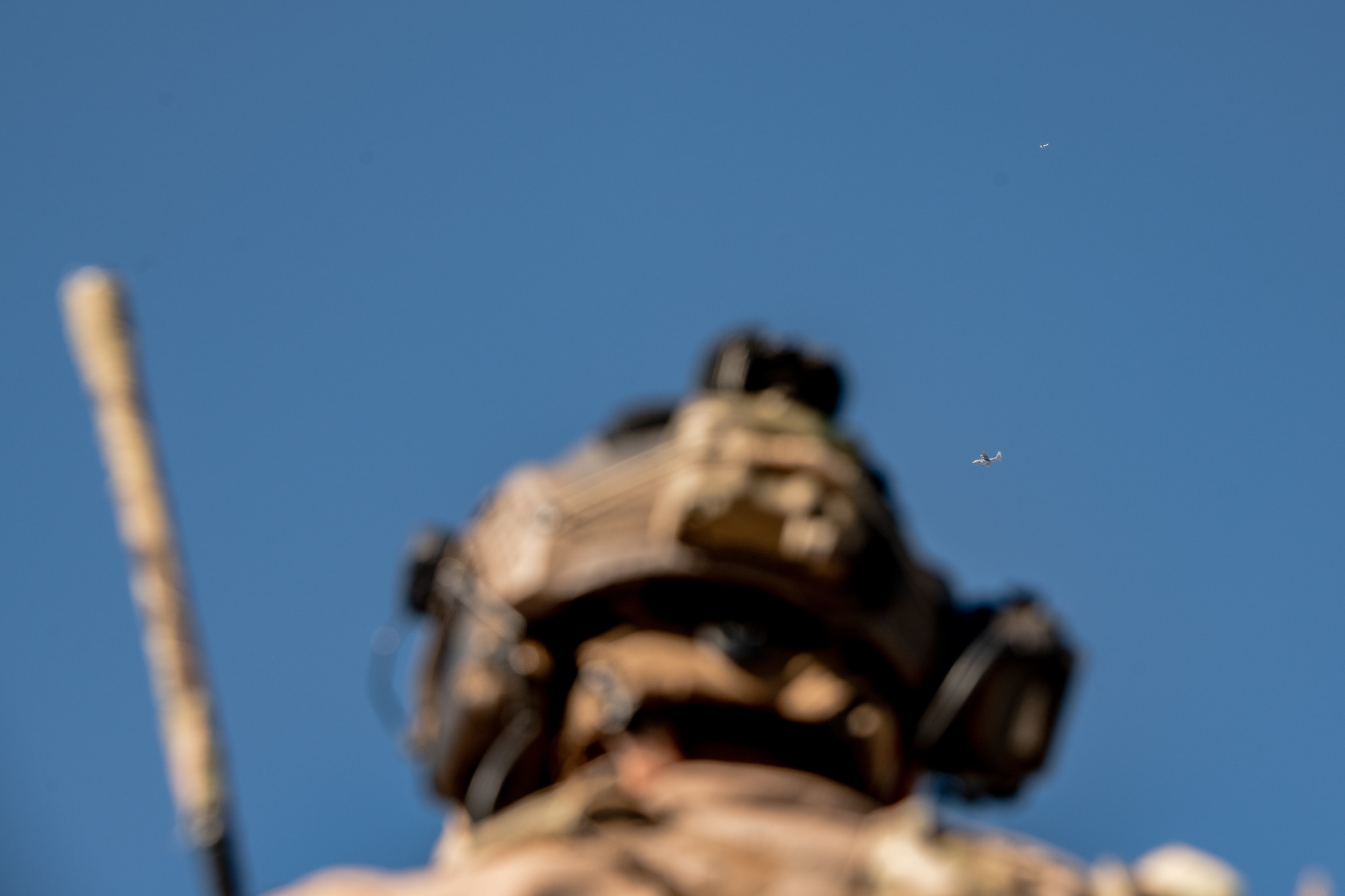 two airplanes fly in sky with man watching them