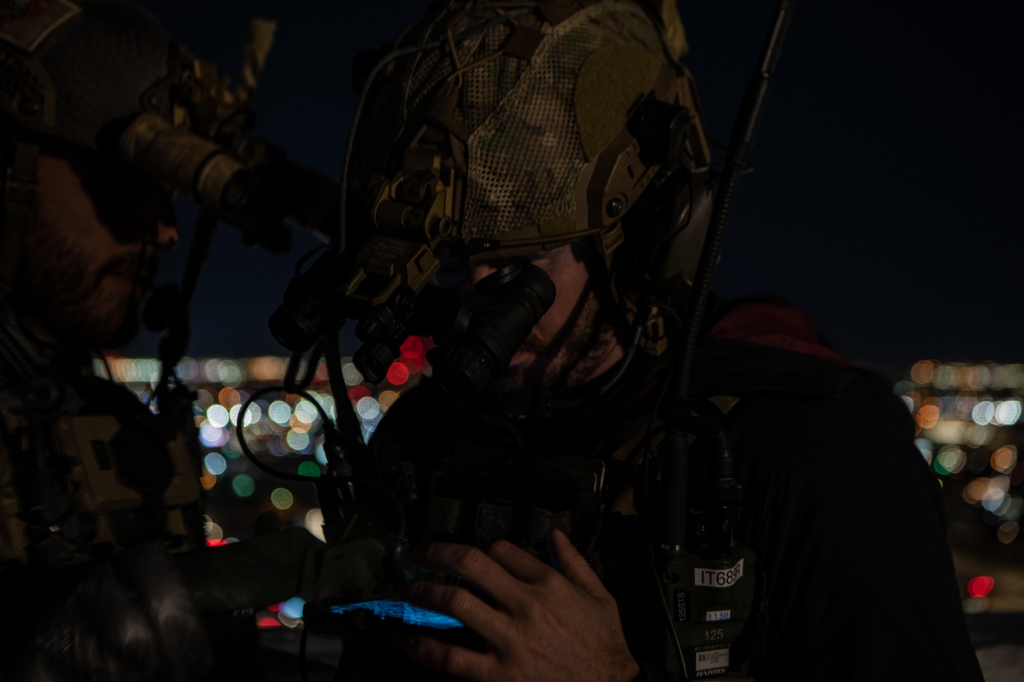 two men looking through night vision goggles