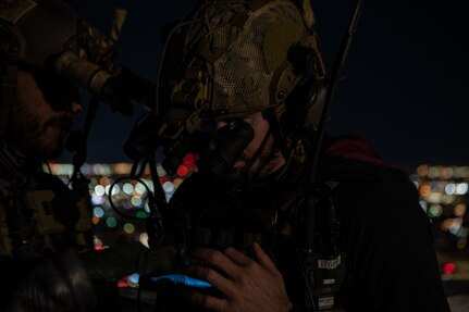 two men looking through night vision goggles
