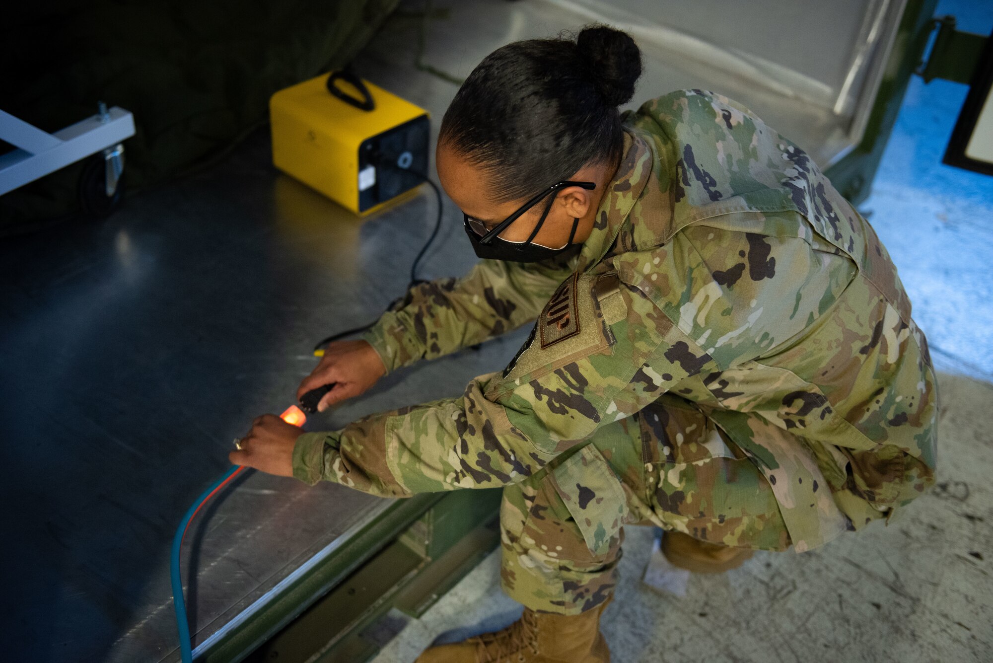 U.S. Air Force Master Sgt. Adriane M. Pope, 87th Logistics Readiness Squadron individual protective equipment section chief, plugs in a 10-lb ozone generator into an ISU-90 shipping container at Joint Base McGuire-Dix-Lakehurst, N.J., Feb. 10, 2022. This sanitation method is being tested in order to develop a less cumbersome solution for cleaning deployment gear. (U.S. Air Force photo by Airman 1st Class Sergio Avalos)